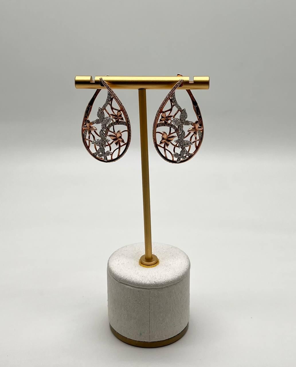 Intricate and elegant, these exquisite drop earrings feature a delicate lattice design adorned with shimmering diamonds and butterfly motifs. The teardrop shape is beautifully crafted, showcasing a harmonious blend of textures and patterns. 14K