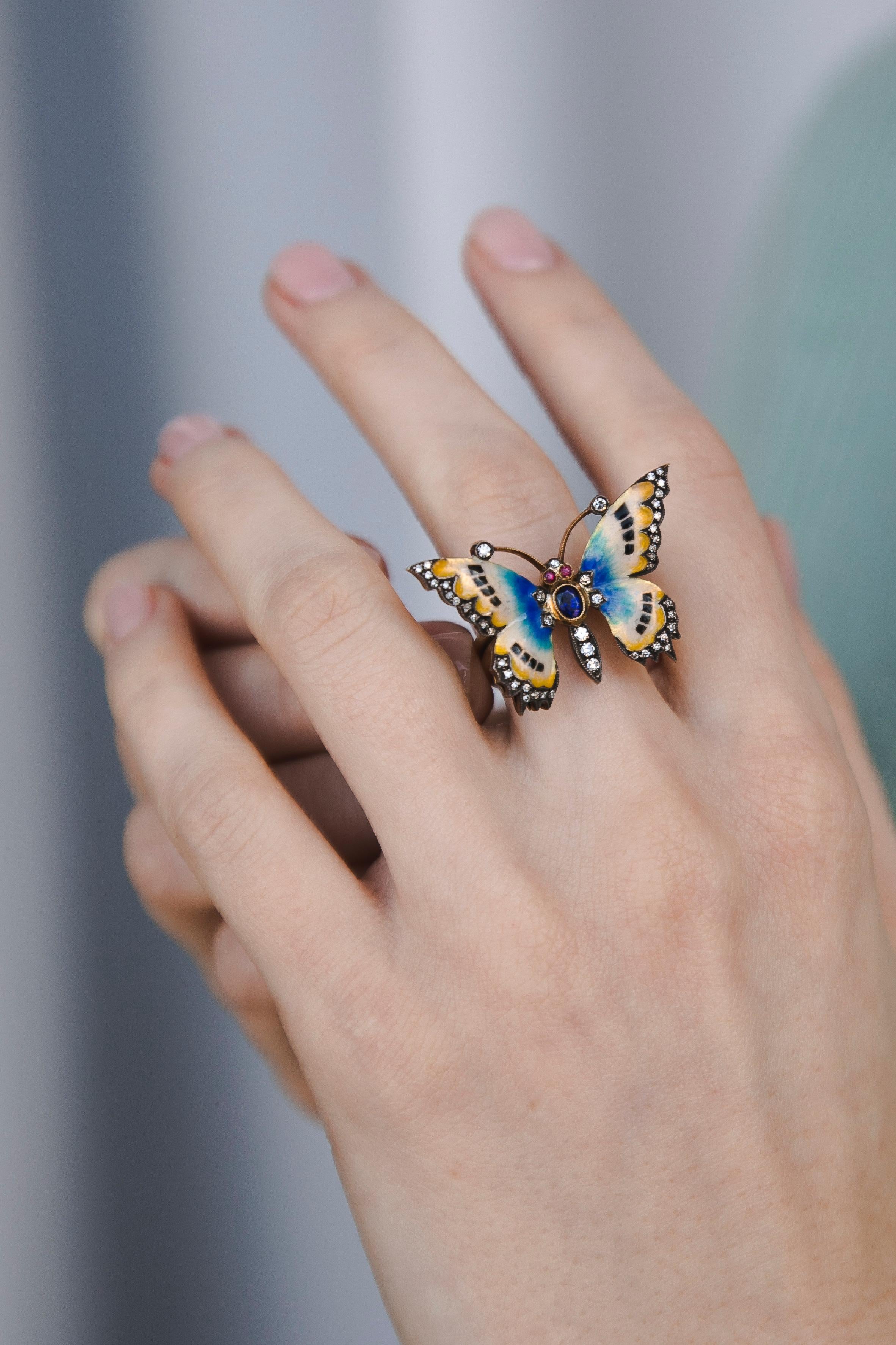 Bague papillon en émail couleur saphir diamants. Le papillon coloré est représenté avec tous les petits détails d'un maître bijoutier. Diamants sertis sur les bords des ailes et du corps. Le dégradé de couleurs de l'émail est tout simplement