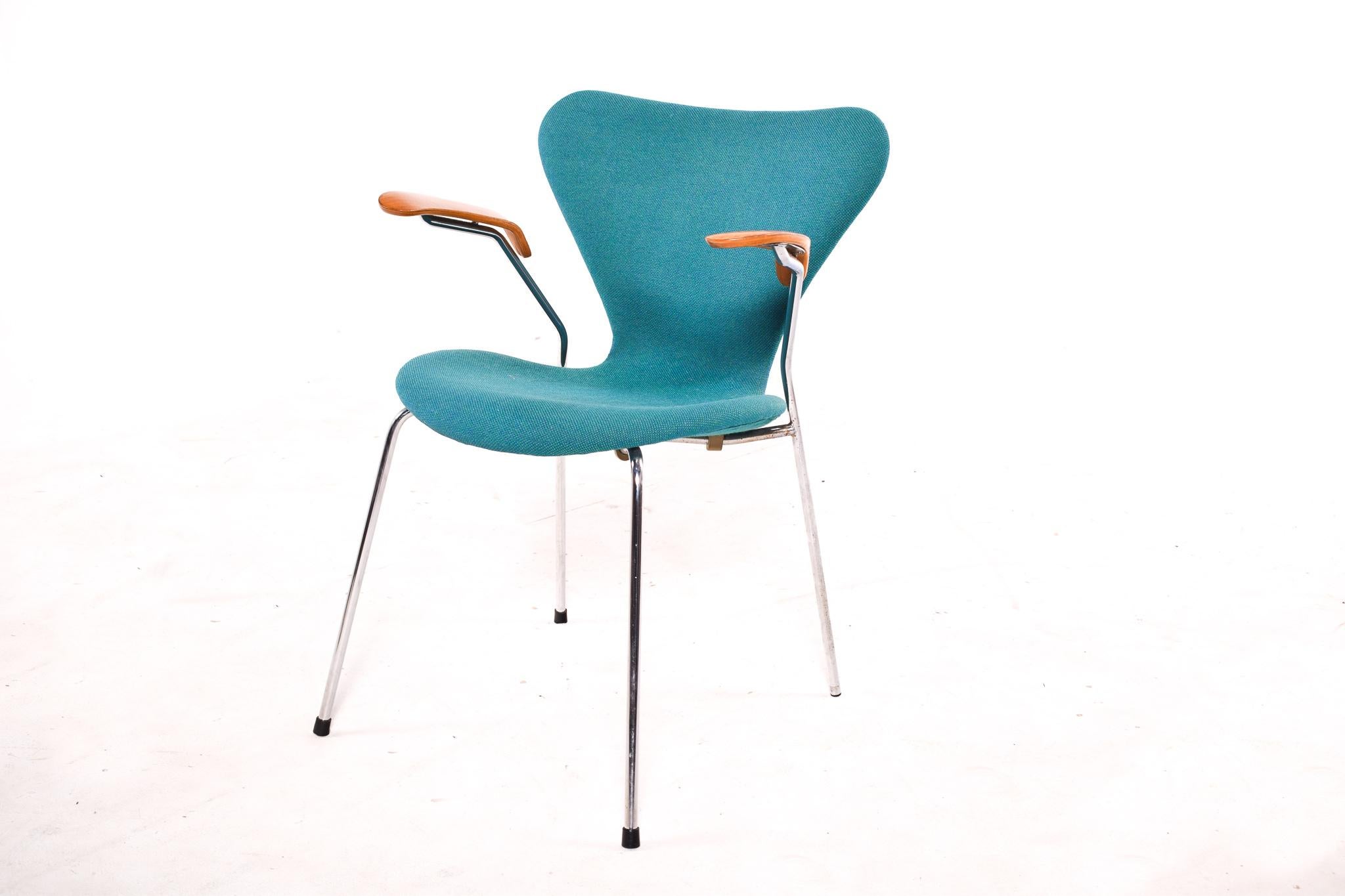 Famous series 7 armchair, Arne Jacobsen design, with turquoise upholstery in fabric, produced by Fritz Hansen. Metal structure, seat and back are made of molded plywood. The armrests is in plywood. It's signed underside of the seat.