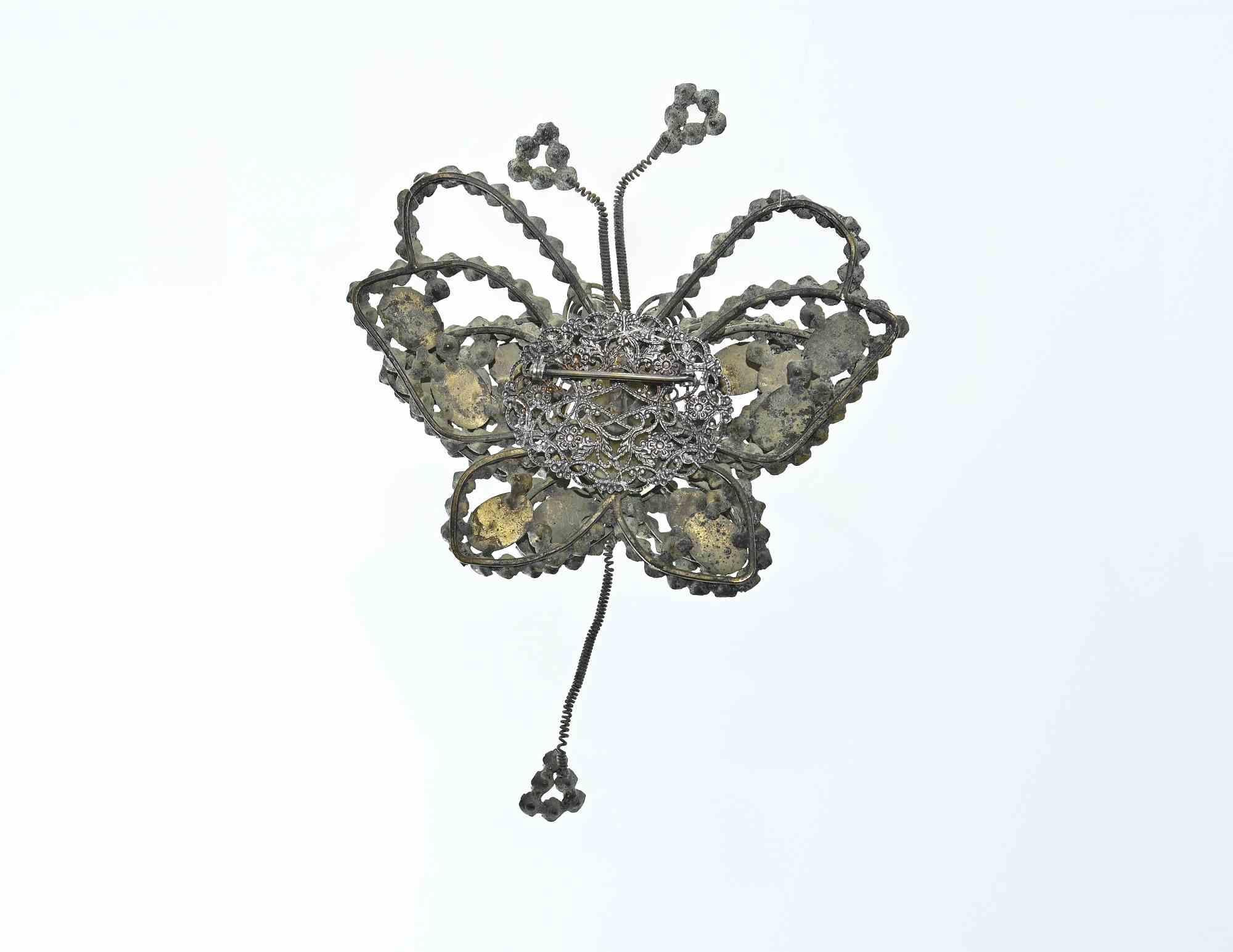 Butterfly-shaped brooch is a handmade object realized in the 1930s.

Craftmanship, 17 x 12 cm.   

Some stones are missing and the iron is ruined due to age.

Vintage collectible item.  

