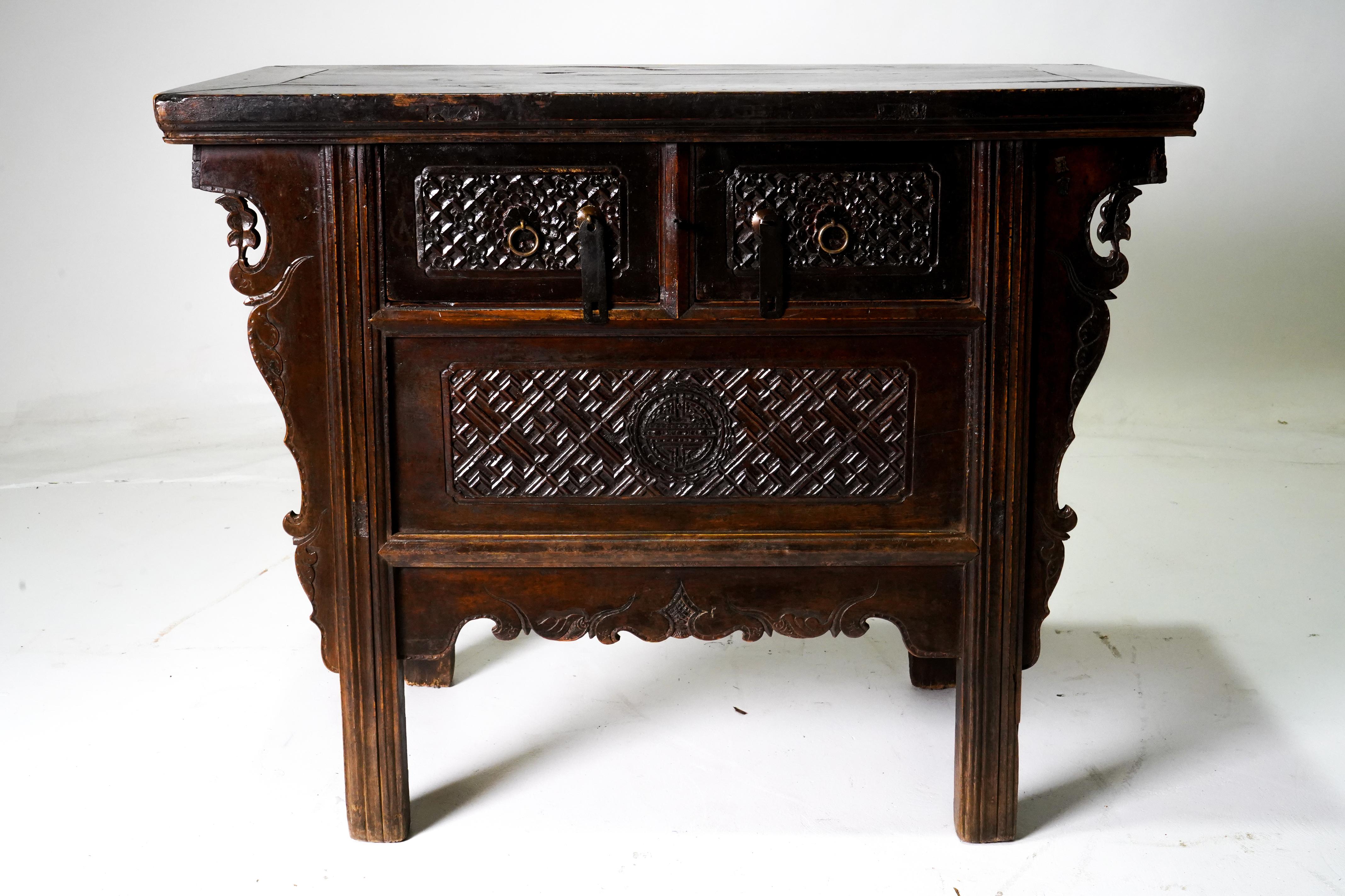 This elegant small Chinse coffer, called a butterfly cabinet, features a floating panel top sitting above two carved drawers, each and fitted with brass hardware. Beneath the drawers is a a richly carved floating panel, which hides interior storage.