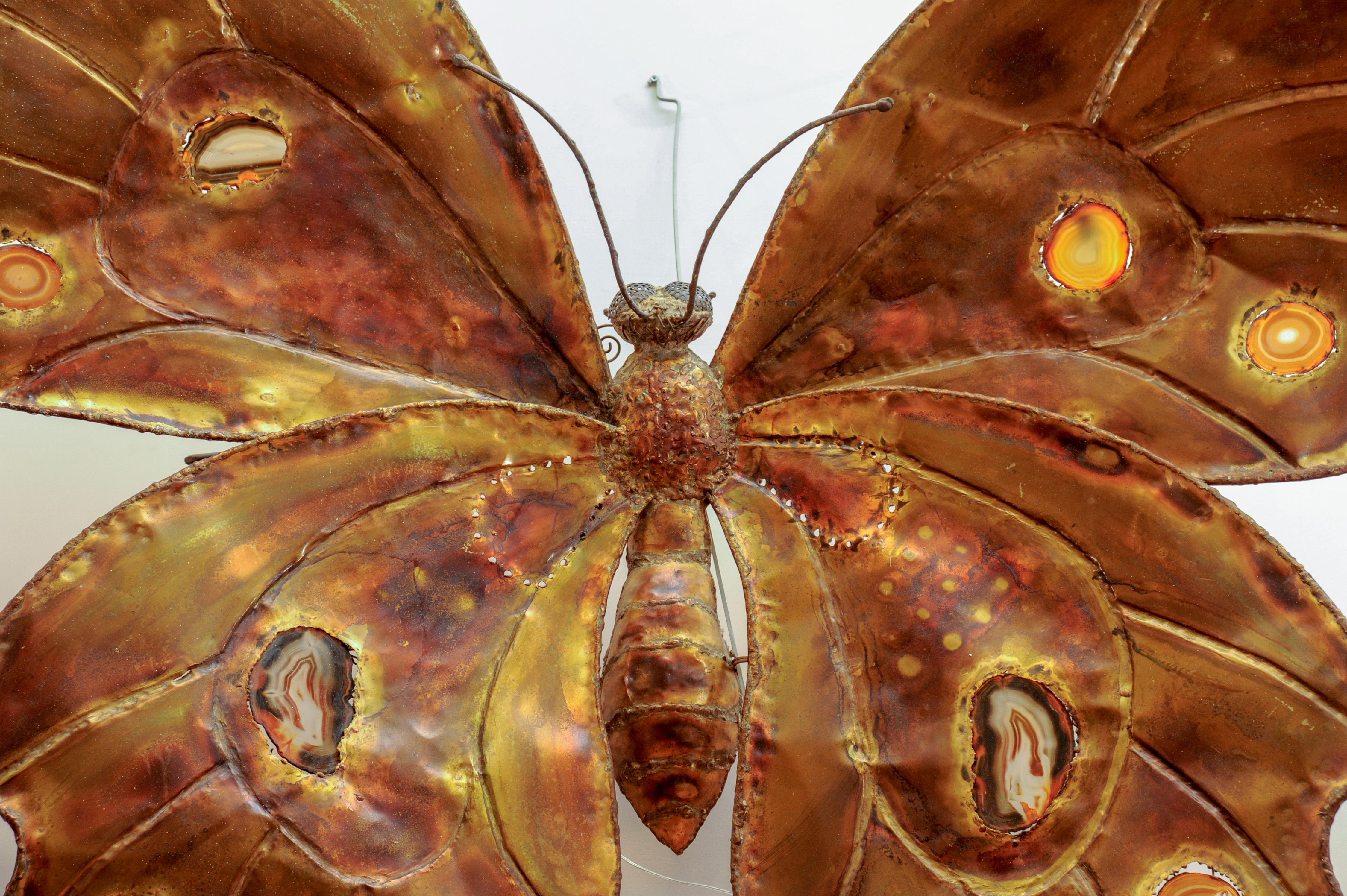 This monumental butterfly shaped sconce is entirely handmade by Henri Fernandez. It is made in brass with slices of agate hiding four light bulbs.