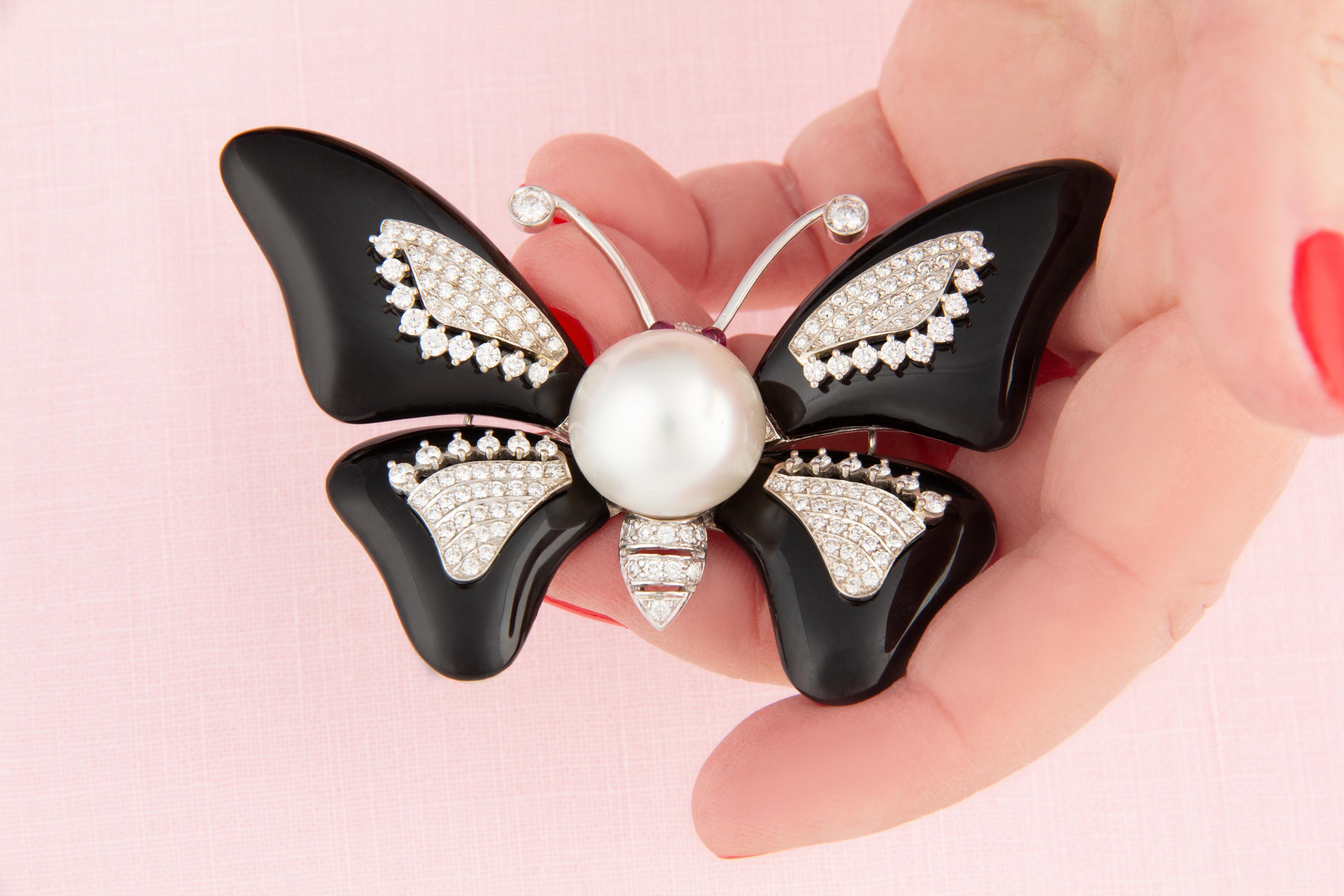 Questa spilla a farfalla presenta al centro una splendida perla dei Mari del Sud di 18 mm di diametro. La perla non è trattata. Mostra una bellissima madreperla e il suo colore naturale e la sua lucentezza non sono stati migliorati in alcun modo. La