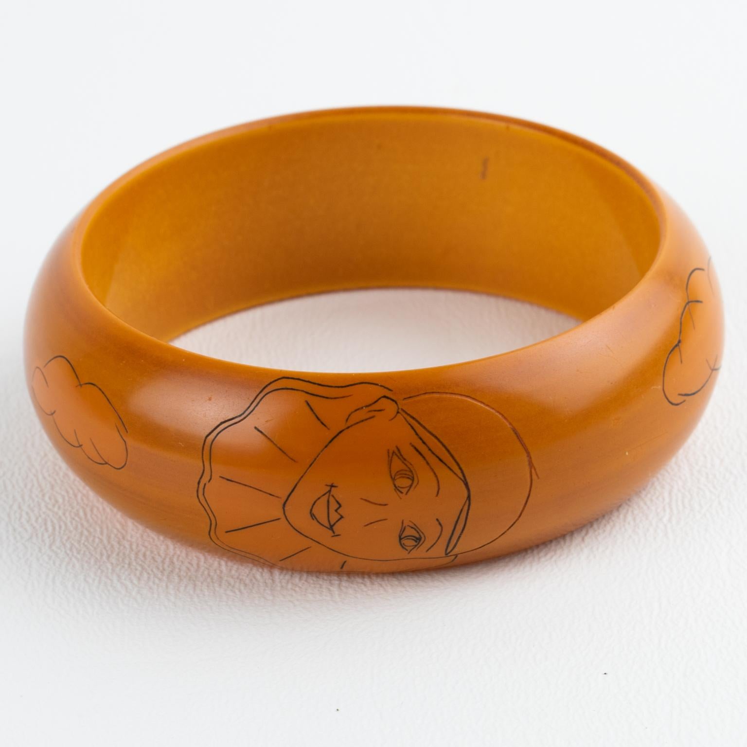 This exquisite Bakelite bracelet bangle with pierrot or clown design was created by Butler & Wilson around 1975. The chunky domed shape has a warm butterscotch color and black contrasting designs. The rare bracelet is adorned with one pierrot face