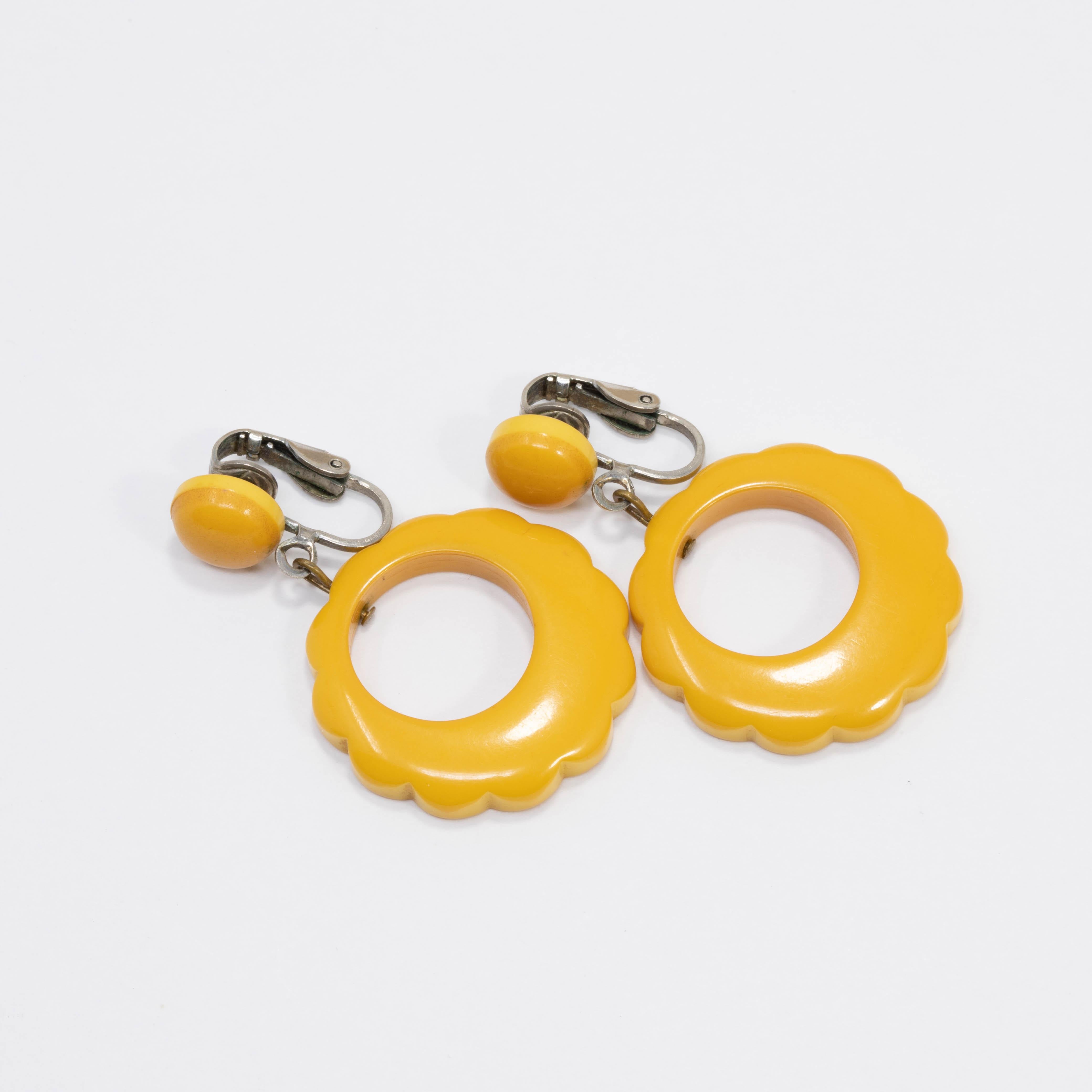 Spectacular pair of bakelite earrings! Bright butterscotch yellow bakelite accents hang off of studded silver-tone clip ons.

