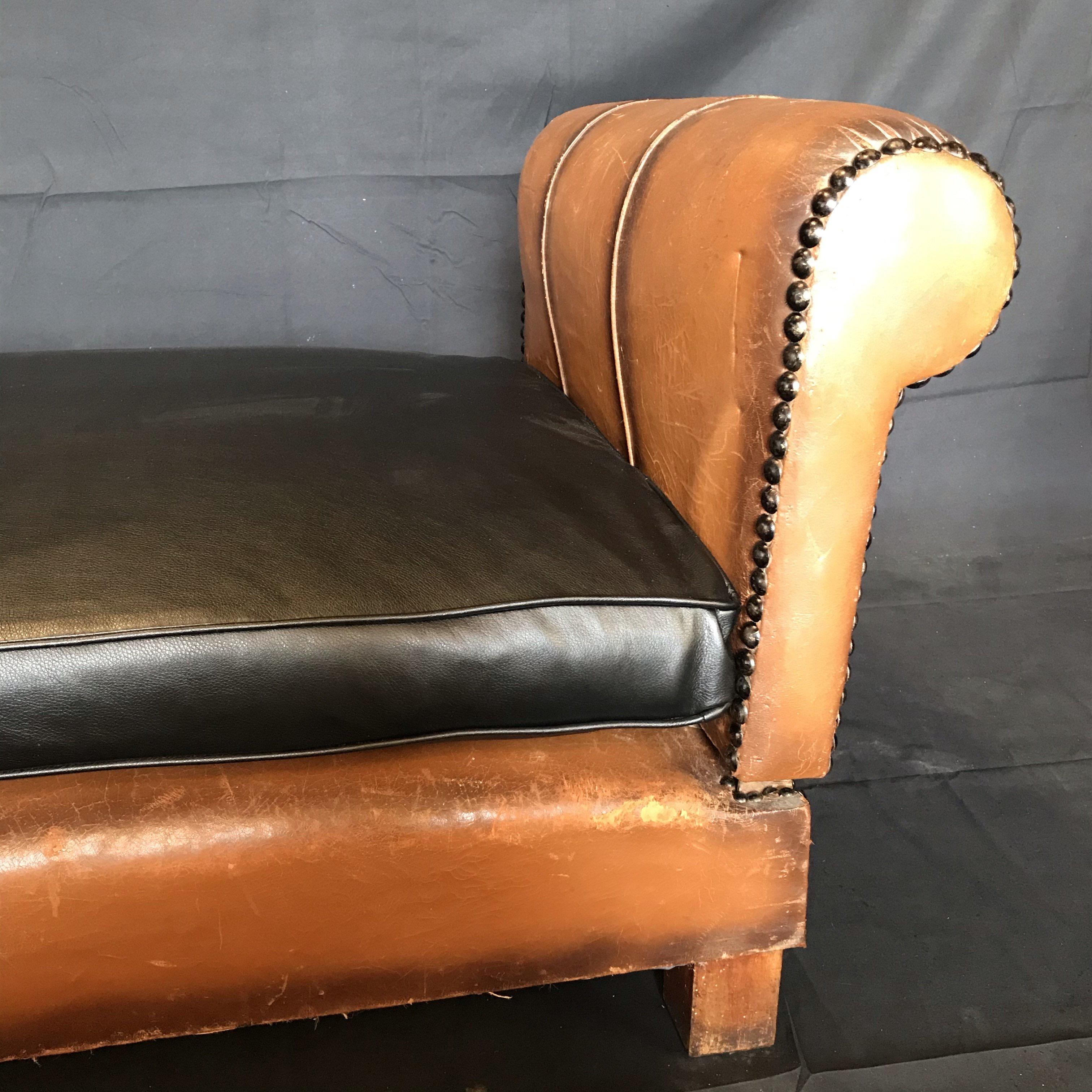 This versatile French deco daybed circa late 1930s can be converted from a bench to daybed, when the arms are removed and reoriented into the appropriate frame fittings. The dark seams complement both the newly reupholstered black faux leather
