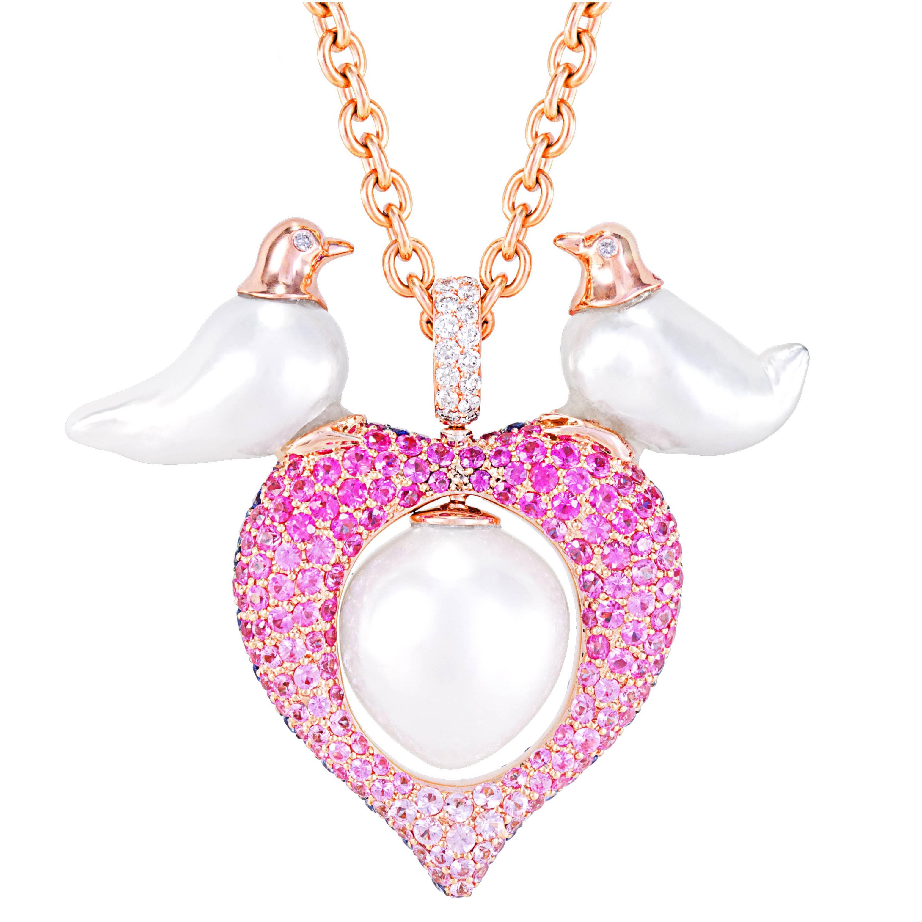 This charming pendent is created featuring Australian South Sea Pearls.  Two small Baroque pearls measuring 9-10mm are effortlessly transformed into two little birds, they sit upon a double sided heart, set in pink and blue sapphires, that have been