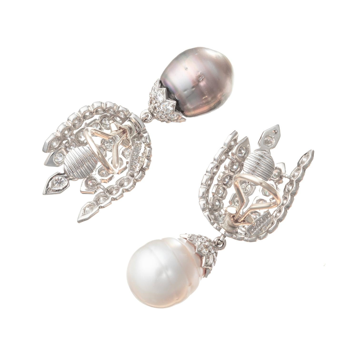 These fine vintage day and night clip-on pendant earrings were designed by Bvcciari.  One earring features a creamy-white cultured South Sea pearl drop and the other has a gray cultured Tahitian pearl drop.  The earrings are suspended from round-cut
