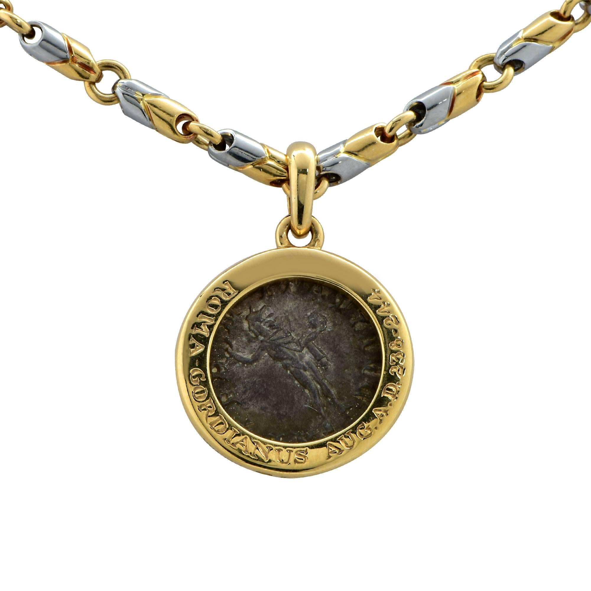18 Karat Yellow and Stainless Steel Bvlgari chain measuring 20 inches in length, 12.3mm wide, with an ancient Roma Gordianus Aug A.D 238-244 coin set in 18 karat yellow gold, measuring 22.2mm in diameter. 

Our pieces are all accompanied by an