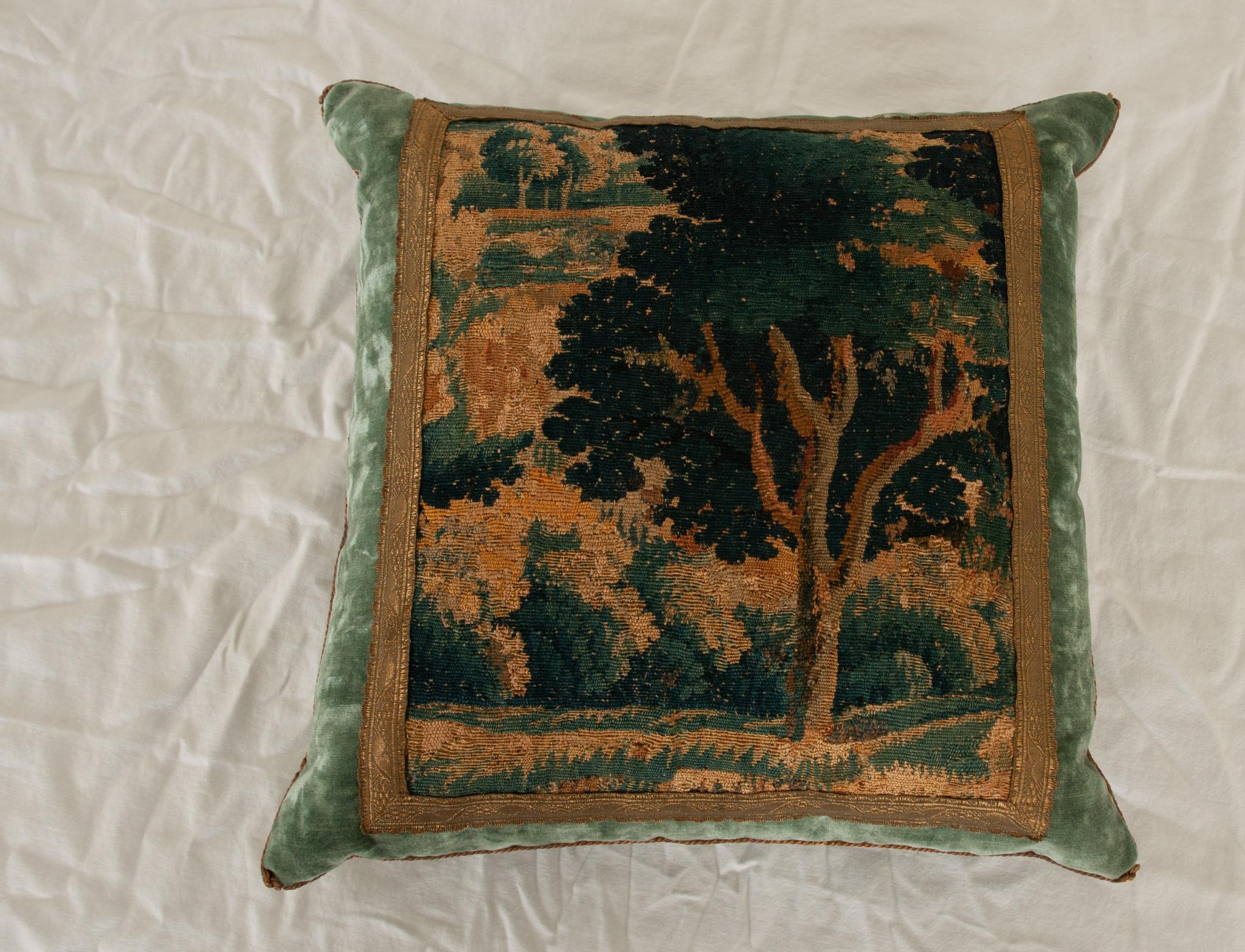 Late 17th to early 18th century Flemish needlepoint tapestry fragment depicting a countryside estate in shades of green, blue, and gold. Framed with antique gold metallic galon with a floral motif on stunning blue velvet. Vintage gold metallic