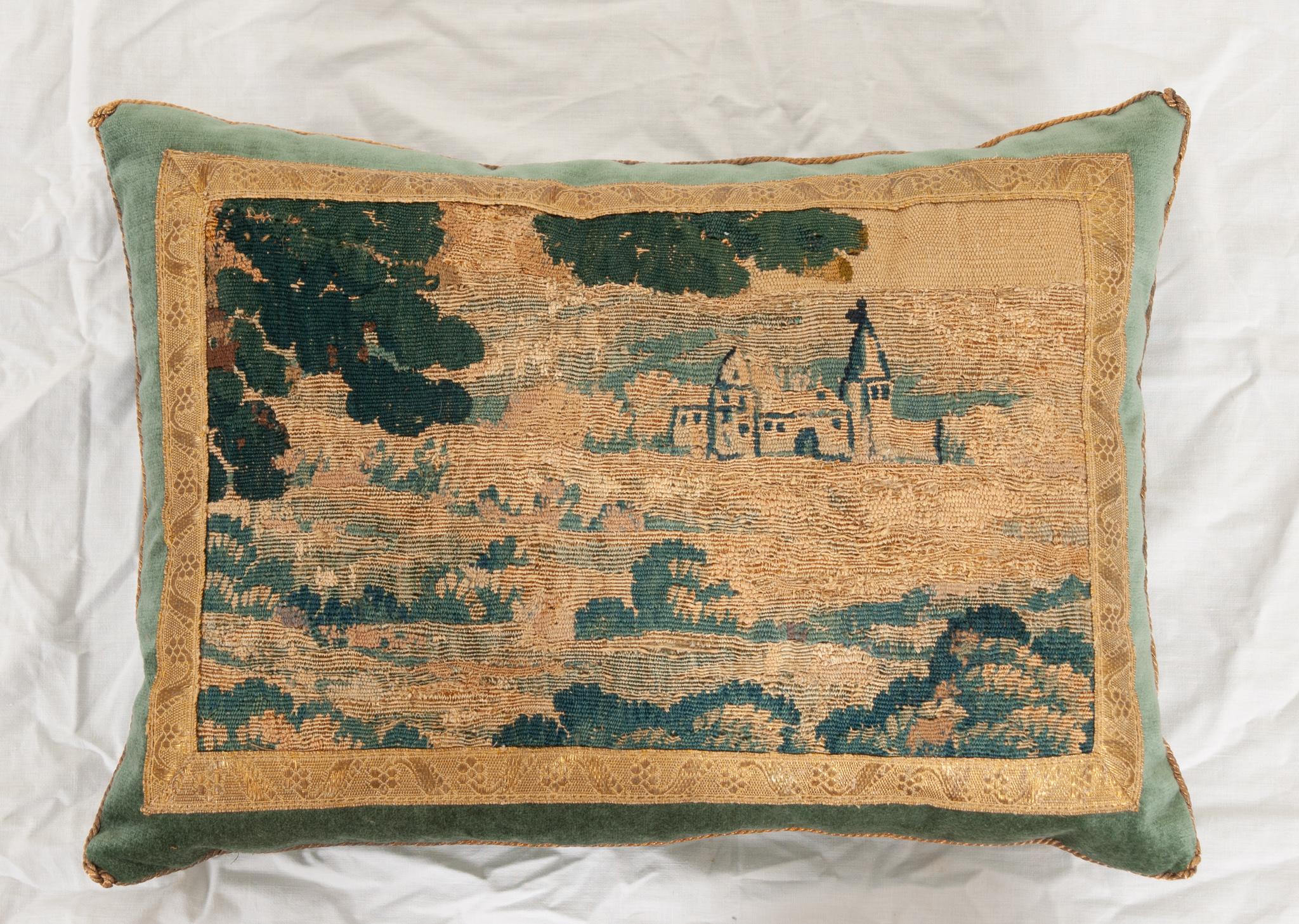 Late 17th to early 18th century Flemish needlepoint tapestry fragment depicting a countryside estate in shades of green, blue, and gold. Framed with antique gold metallic galon with a floral motif on stunning blue velvet. Vintage gold metallic