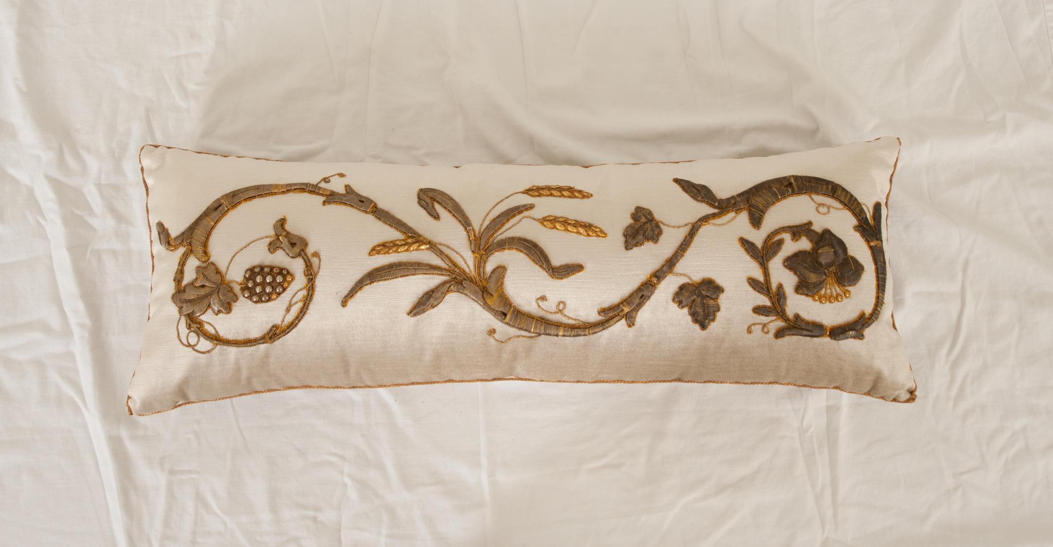 Antique European raised gold metallic embroidery depicting vining flowers and grapes bordered with antique gold metallic galon on velvet. Hand trimmed with vintage gold metallic cording, knotted in the corners. Down filled.