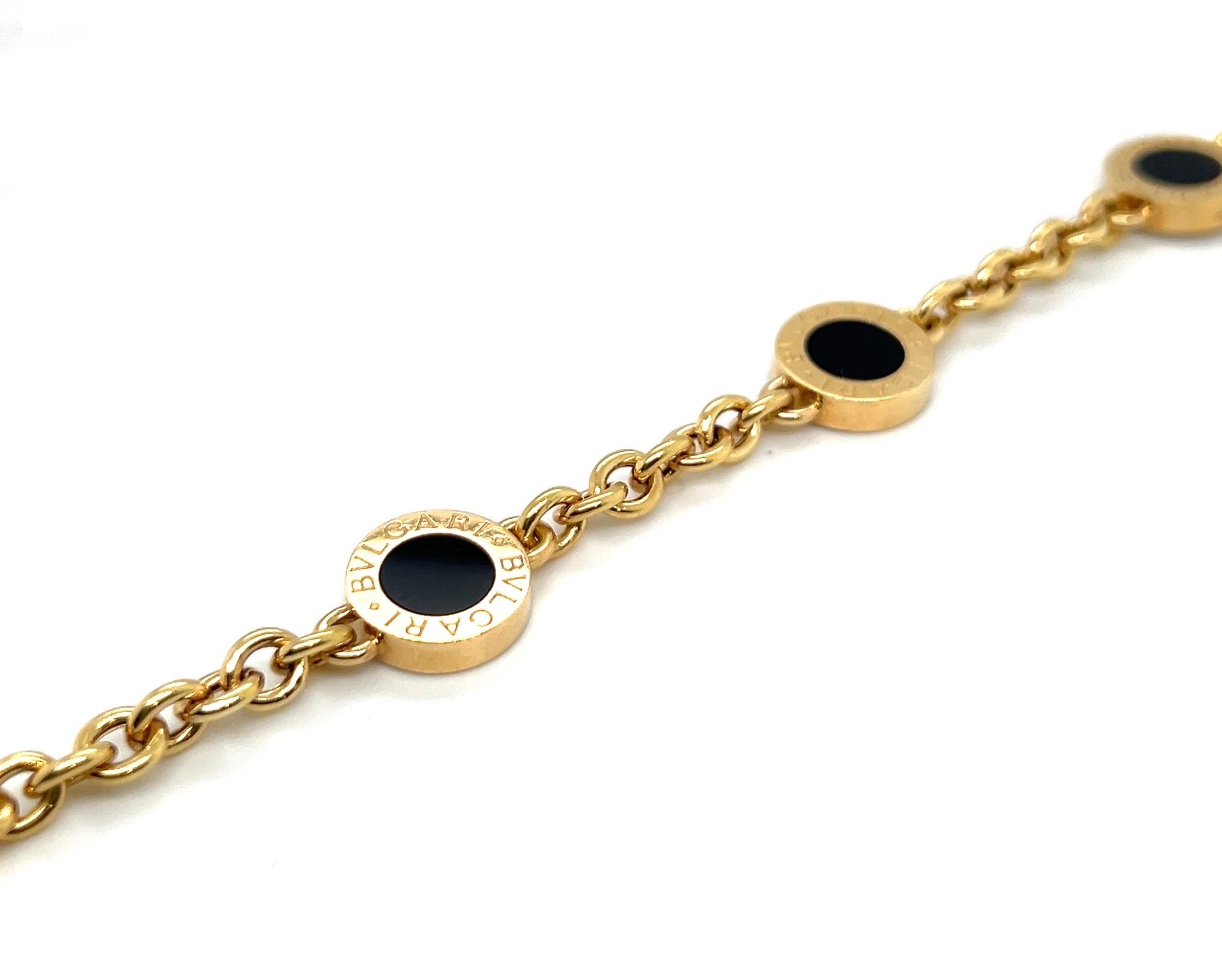 Classic 18 karat yellow gold and onyx bracelet by renowned Italian jewelry house Bvlgari.

Crafted in 750 yellow gold, this smart cable chain bracelet features four circular motifs, each set with an onyx disc framed by a gold border engraved Bvlgari