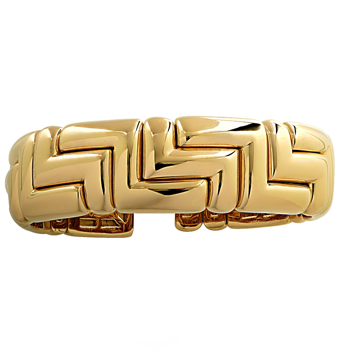 Stunning Bvlgari cuff bangle bracelet crafted in 18 karat yellow gold featuring yellow gold geometric links interlocking to create a bold and alluring design. This striking bangle cuff bracelet measures .72 of an inch in length and has an inner