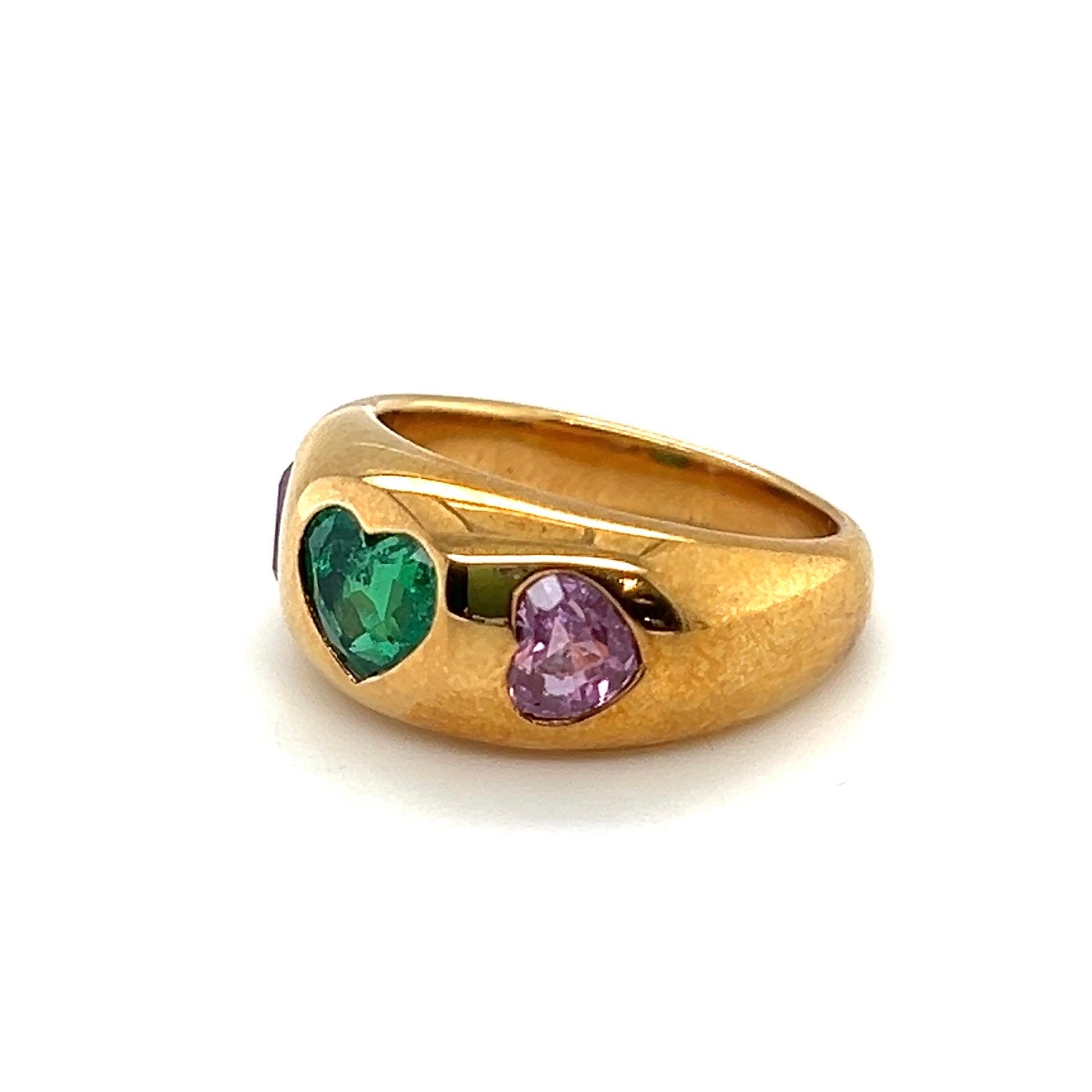 Adorable 18 karat yellow gold, emerald and pink sapphire band ring by the renowned Italian brand Bvlgari.

Crafted in 18 karat yellow gold, slightly bombé band ring decorated with a fine, vibrant green heart-shaped emerald of approximately 0.8