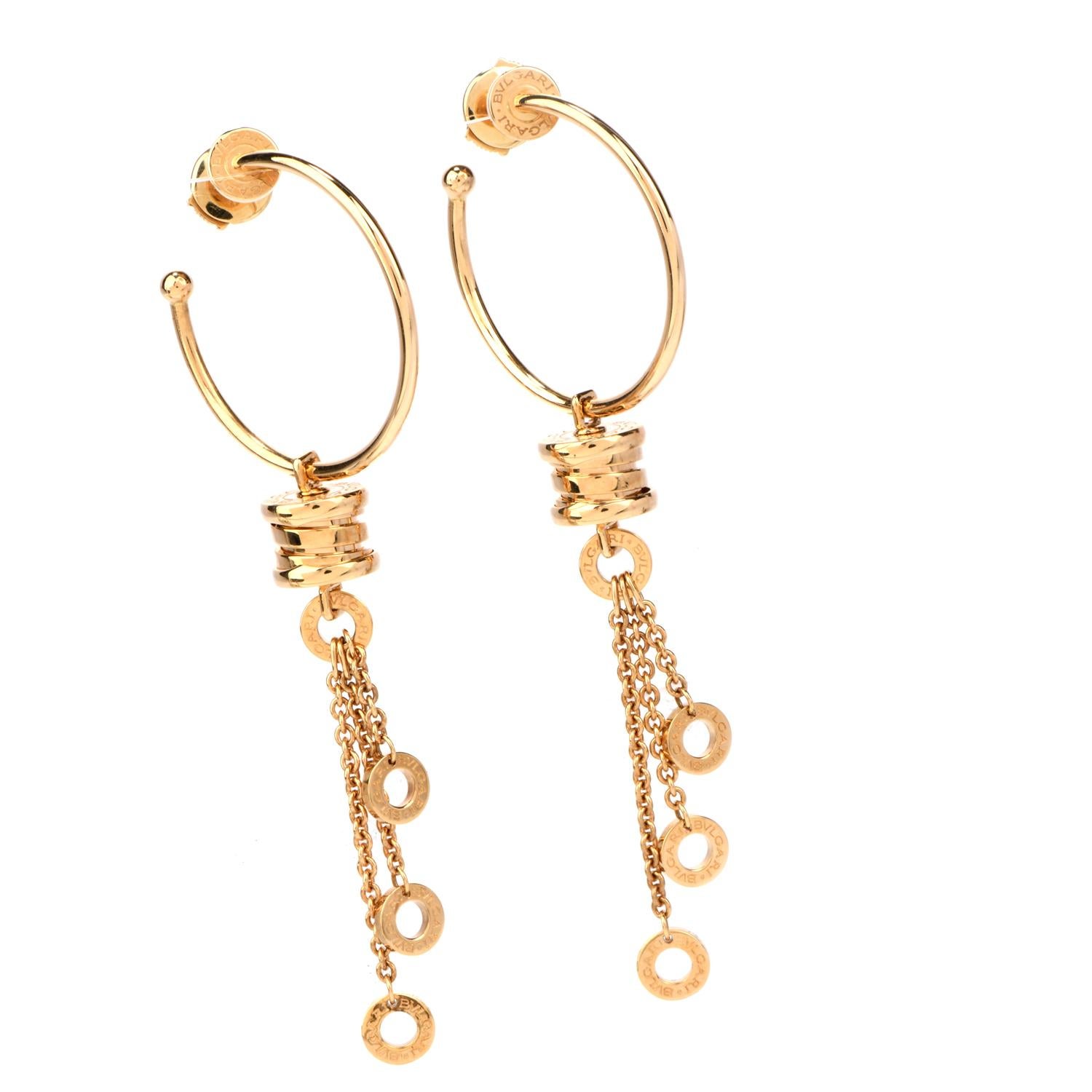 Show your modern and sharp style with these legendary Bvlgari 18K Gold B.Zero1 Dangle Hoop Earrings!  These

collectible earrings are crafted in 18 karat yellow gold.  There are two B.Zero1 style pendants on either hoop, with 8 drop chains with