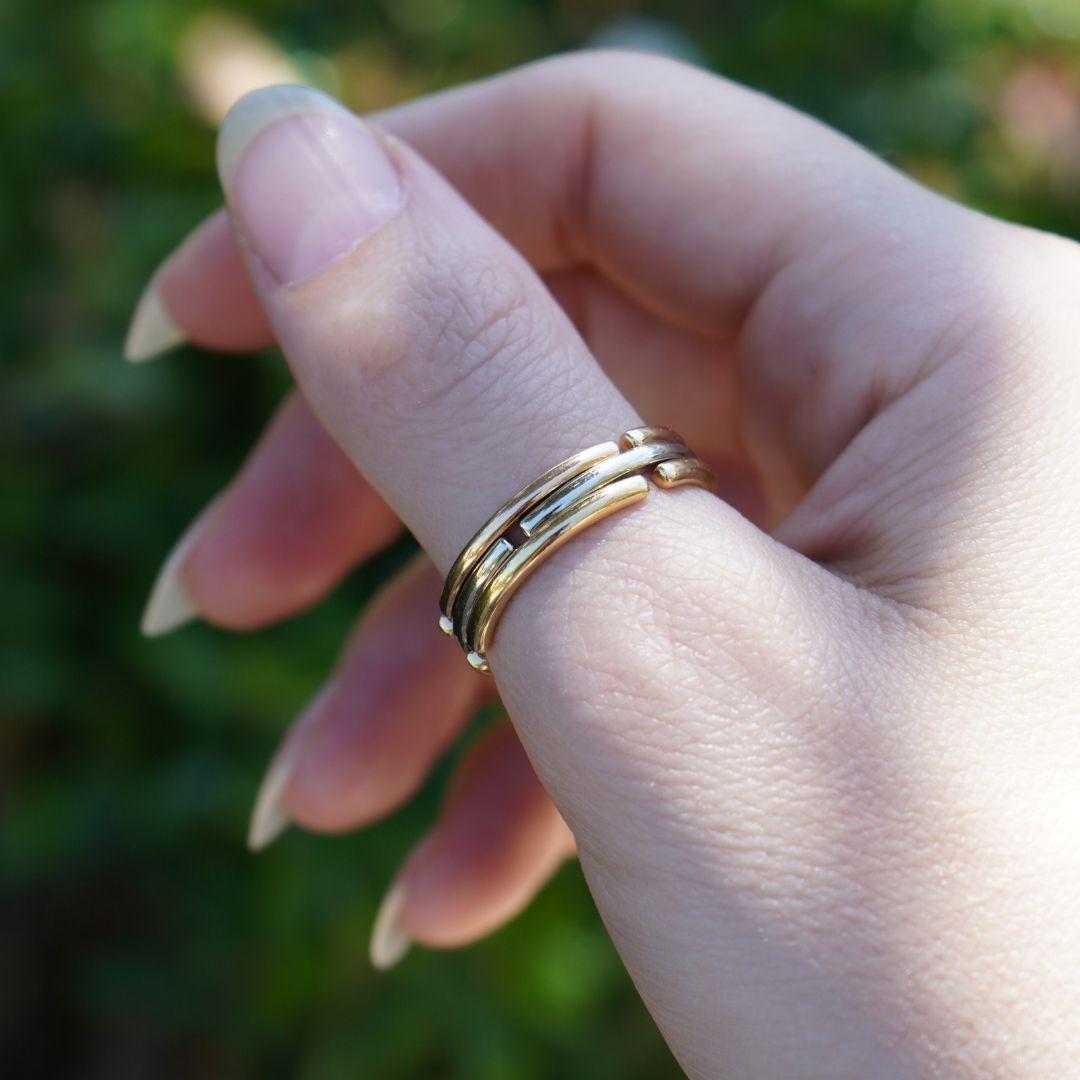 Dieser dreifarbige Klappring von Bvlgari aus 18 Karat Gelb-, Weiß- und Roségold ist ein lustiges Design aus den 1990er Jahren. Das Band ist in einem modularen, zusammenklappbaren Stil gestaltet, der Bvlgaris innovativen Ansatz für das Schmuckdesign
