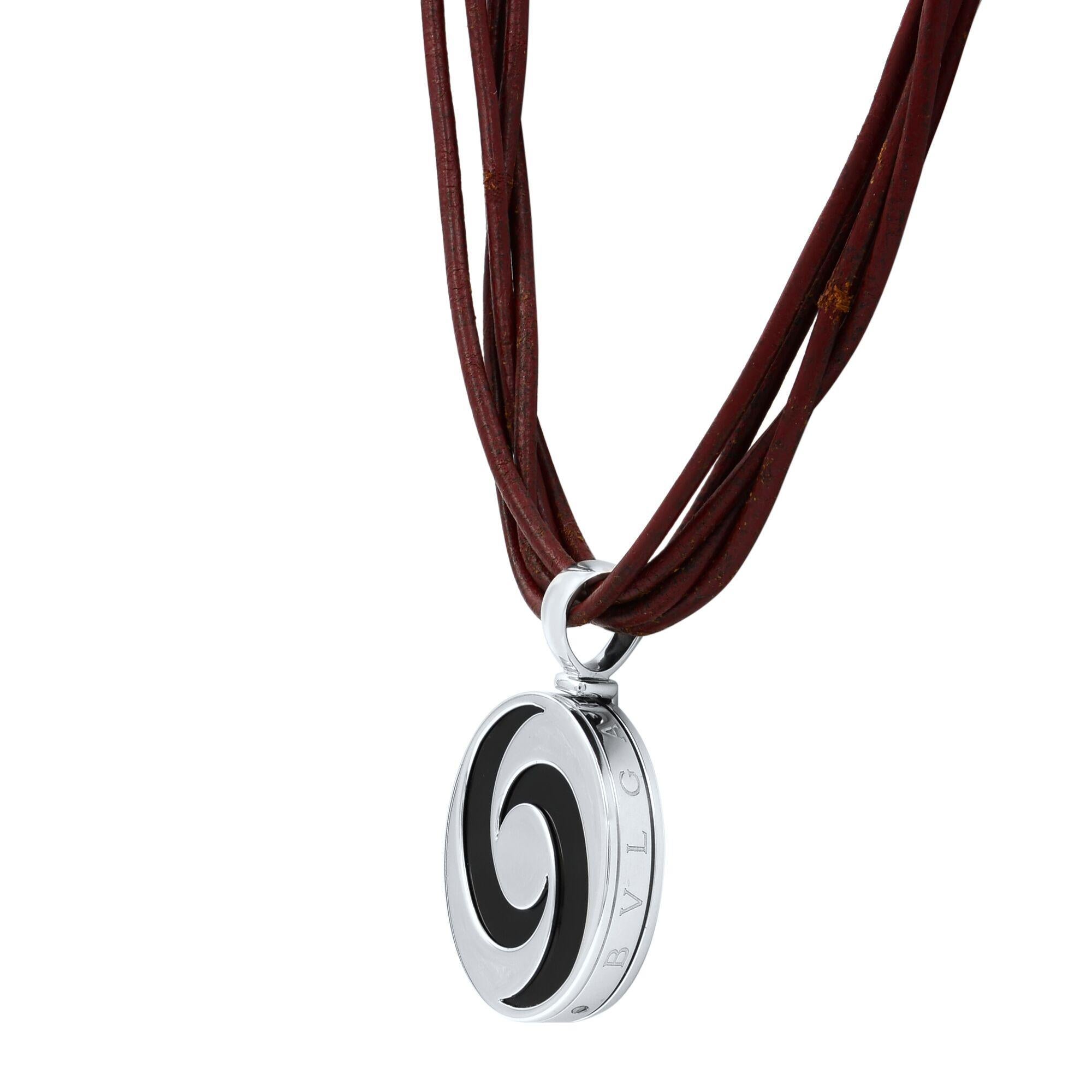Bulgari pendant necklace from the OPTICAL collection, the large round shape has steel case with a black onyx inside the round frame spins creating an optical illusion. It has 18k yellow gold accent engraved BVLGARI around the thick frame. It is