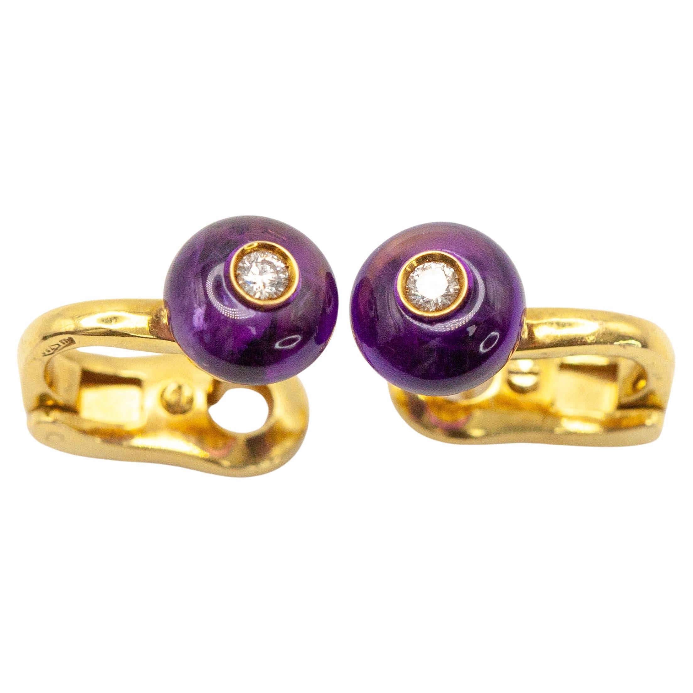 Ein auffälliges Paar Vintage-Ohrringe von Bvlgari aus 18 Karat Gelbgold mit einem violetten Amethyst-Cabochon und einem Diamanten im Brillantschliff in der Mitte. Der leuchtende Amethyst ist in eine gewölbte, polierte Goldfassung gefasst, die ein