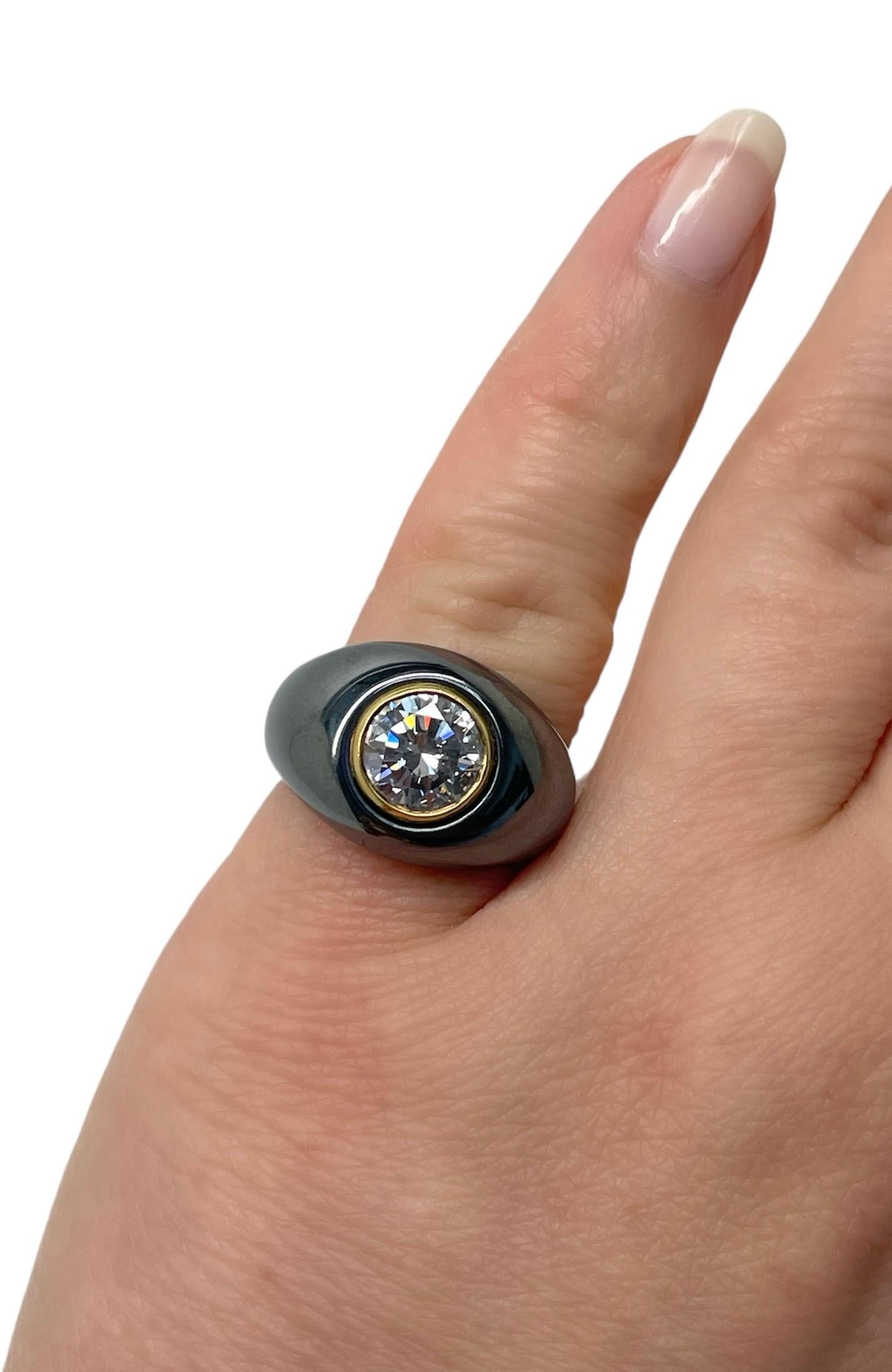 This modern and sleek Bvlgari ring contains a round brilliant cut diamond weighing 1.70 carats in a yellow gold bezel and surrounded by a carved and polished hematite plaque. Mounted in 18 karat yellow gold and skillfully crafted, this ring a