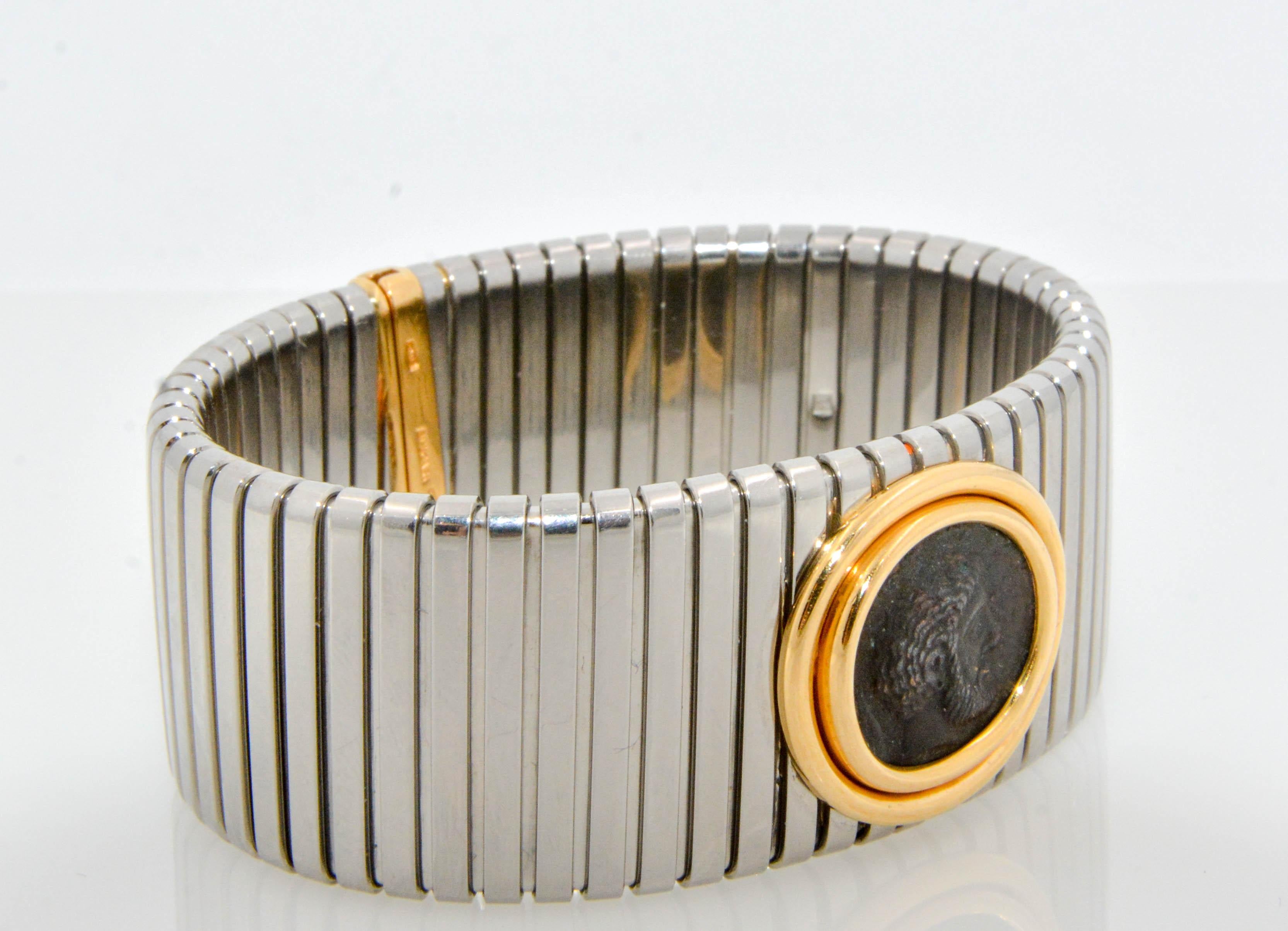 A special & traditional piece from the iconic Monete Collection from Bulgari; an 18K yellow gold/stainless steel tubogas bracelet set with a 4th century Sicilian ancient coin in a bezel center. 

Nicola Bulgari was an enthusiastic coin collector who