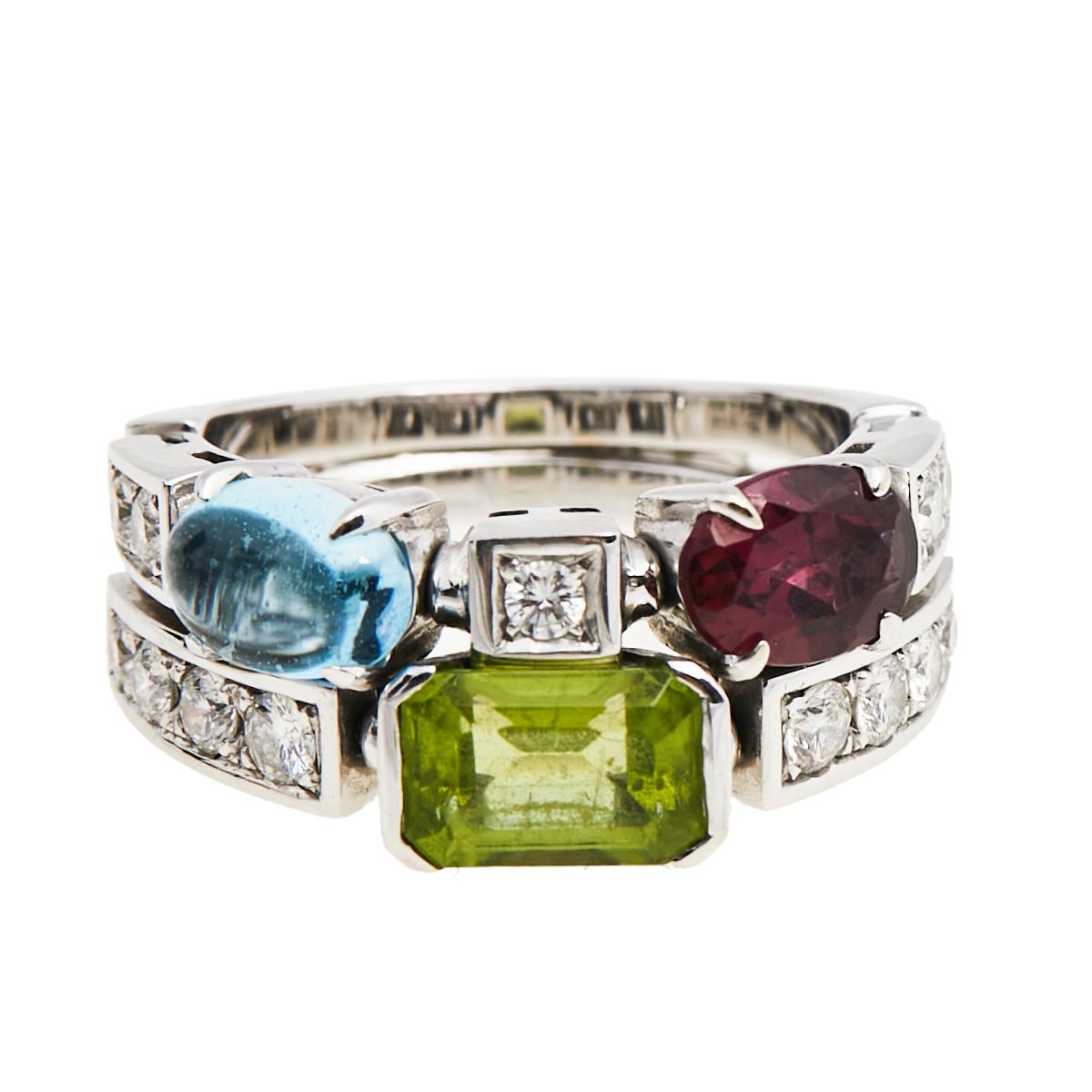 Beautiful and feminine, this ethereal cocktail ring is a statement piece that is designed to complement its wearer on any day. This gorgeous piece is rendered in 18K white gold and has a beautiful assortment of shimmery diamonds, a garnet, peridot,