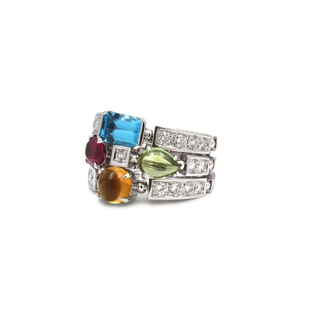 Authentic Bvlgari Allegra ring crafted in 18 karat white gold. The ring consists of three adjacent bands adorned with cabochon citrine, oval-faceted pink tourmaline, pear shape peridot cabochon and emerald cut blue topaz. The ring is set with 21
