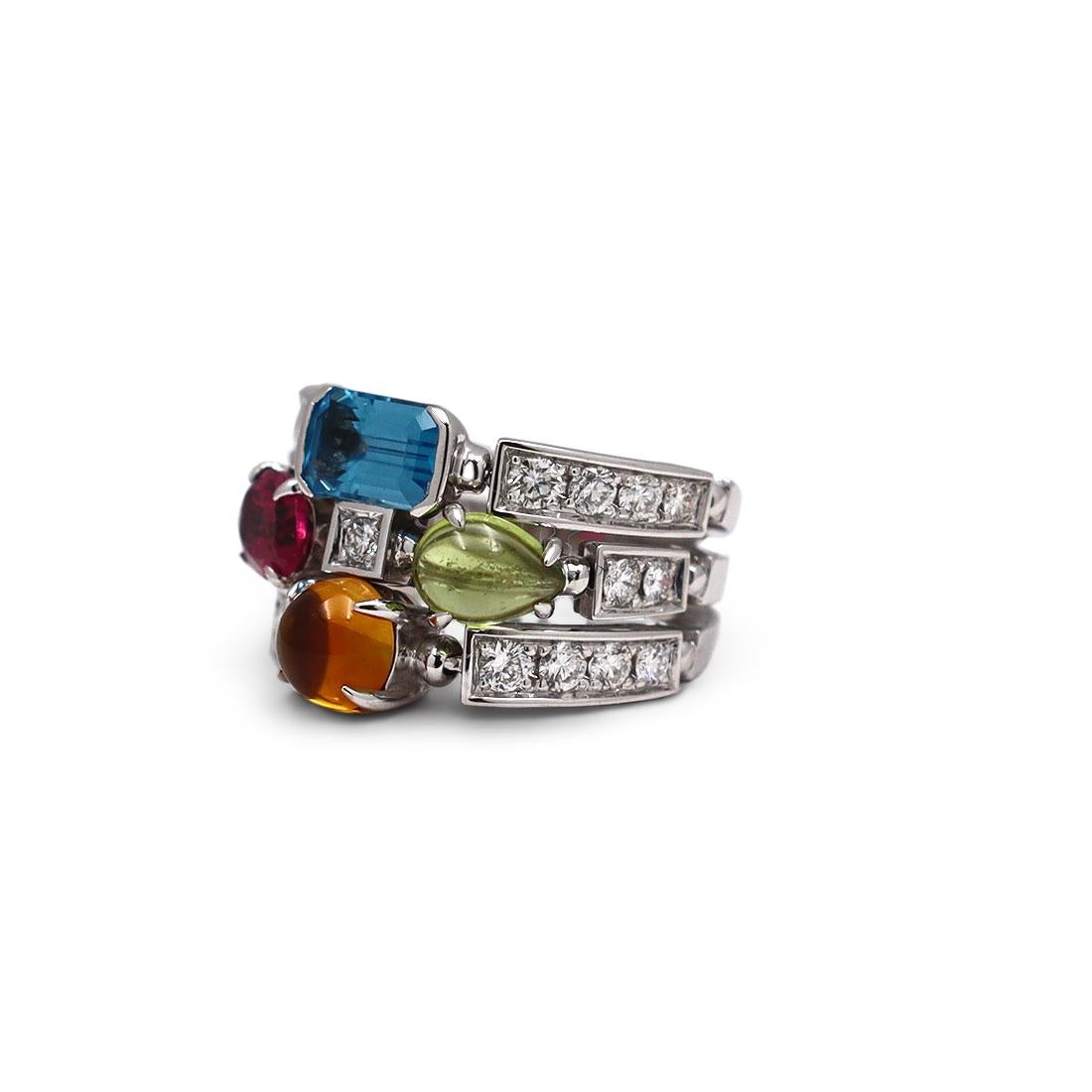 Authentic Bvlgari Allegra ring crafted in 18 karat white gold. The ring consists of three adjacent bands adorned with cabochon citrine, oval-faceted pink tourmaline, pear shape peridot cabochon and emerald cut blue topaz. The ring is set with 21