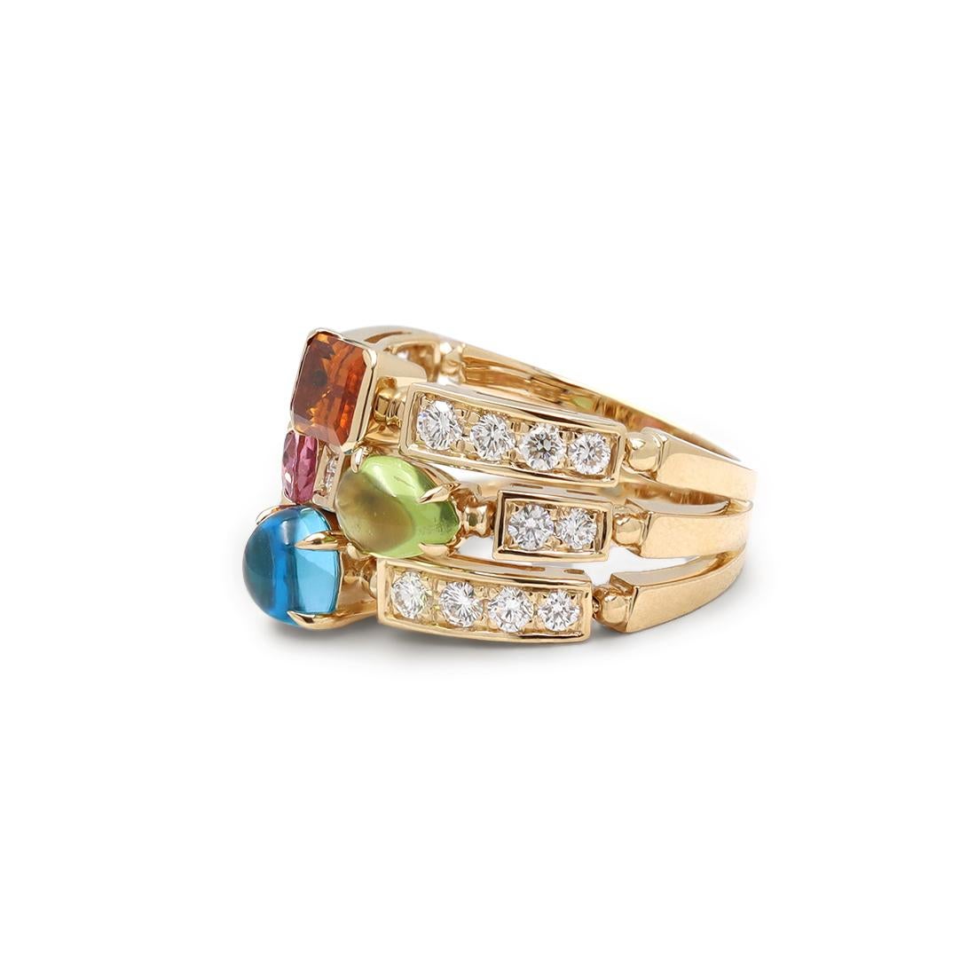 Authentic Bvlgari Allegra ring crafted in 18 karat yellow gold. The ring consists of three adjacent bands adorned with emerald cut citrine, oval-faceted pink tourmaline, pear shape peridot cabochon and cabochon blue topaz. The ring is complemented