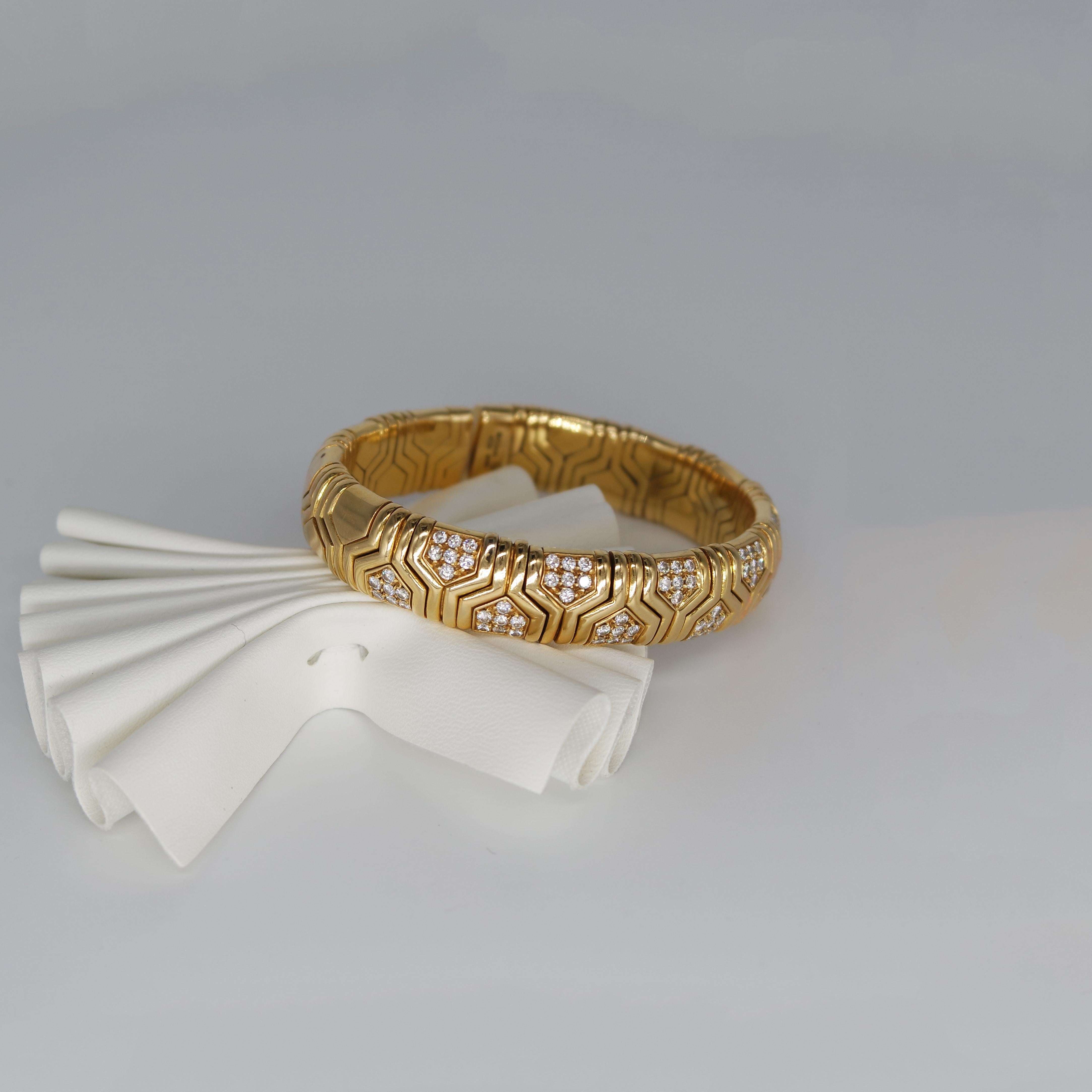 This exquisite authentic Bulgari bangle bracelet of immaculate design and artistic craftsmanship is of Italian provenance, crafted in solid 18K yellow gold, weighing app. 76 grams. Depicting delicate geometrical motives directly inspired by the