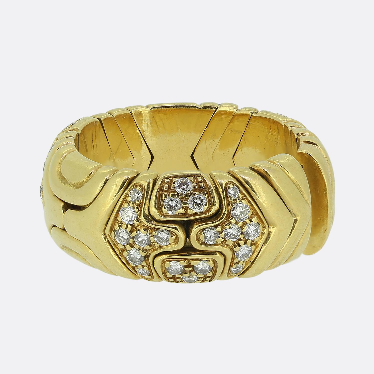 Here we have a bold and luxurious 18ct yellow gold ring from the world renowned Italian jewellery house of Bvlgari. The design features a striking arrangement of brilliant-cut white diamonds, intricately set to form a captivating pattern. The wide