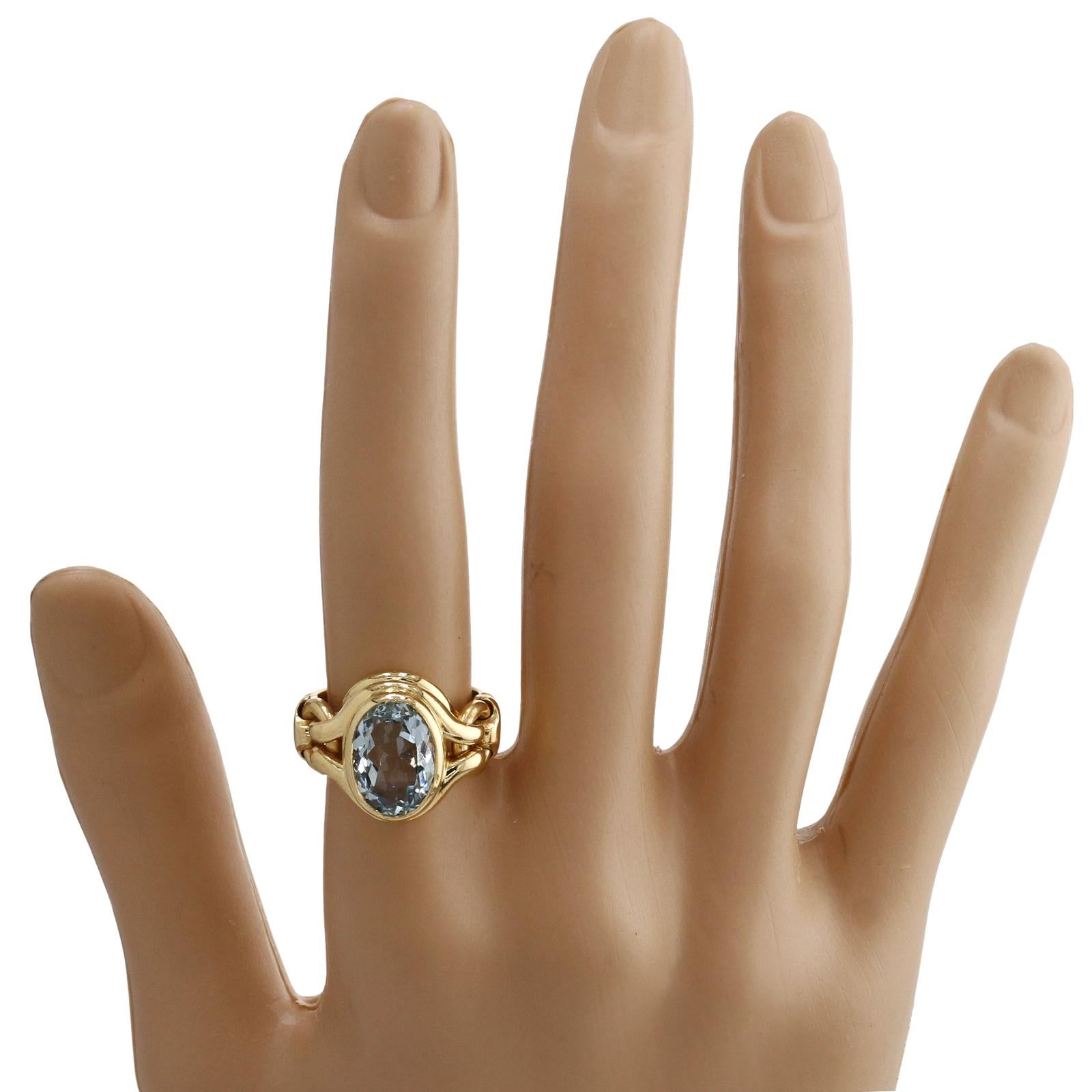 Este elegante anillo auténtico de Bvlgari presenta un divertido diseño flexible elaborado en oro amarillo de 18k y engastado con una aguamarina ovalada de 8,0 mm x 13,0 mm. Fabricado en Italia hacia la década de 1990. Medidas: 18 mm de ancho, 18 mm