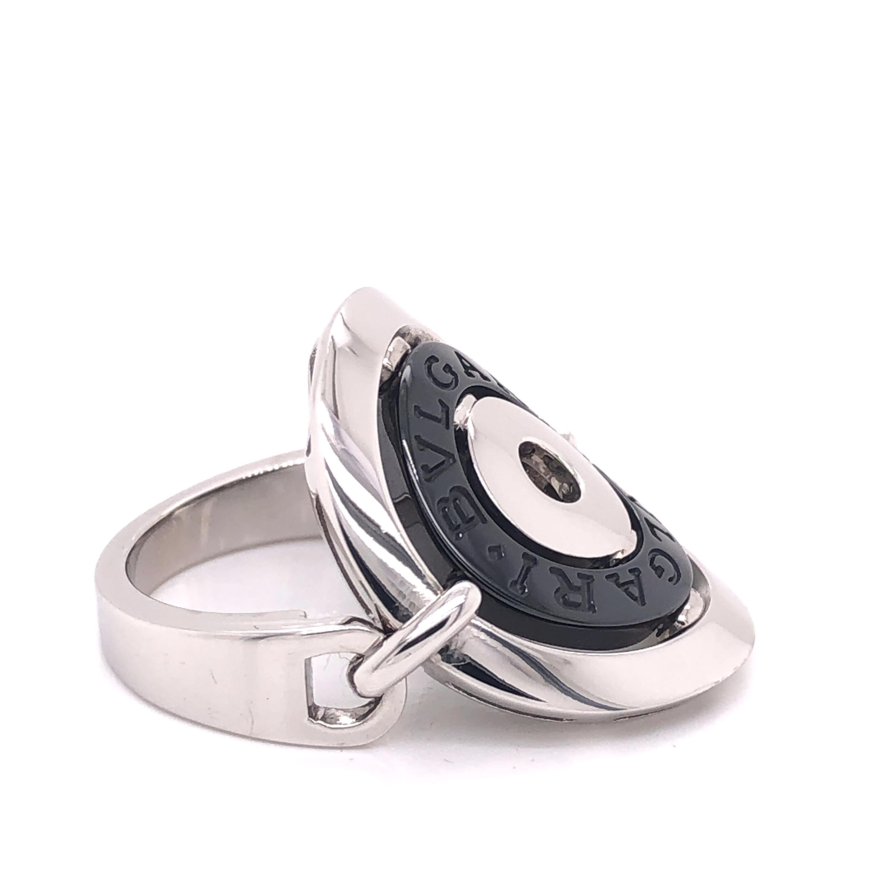 This is a beautiful ring by BVLGARI from the Astrale Cerchi collection, the design is crafted from 18k white gold and is accented with a fine polished finish featuring three circles, the center circle is in black stainless steel hallmarked with the