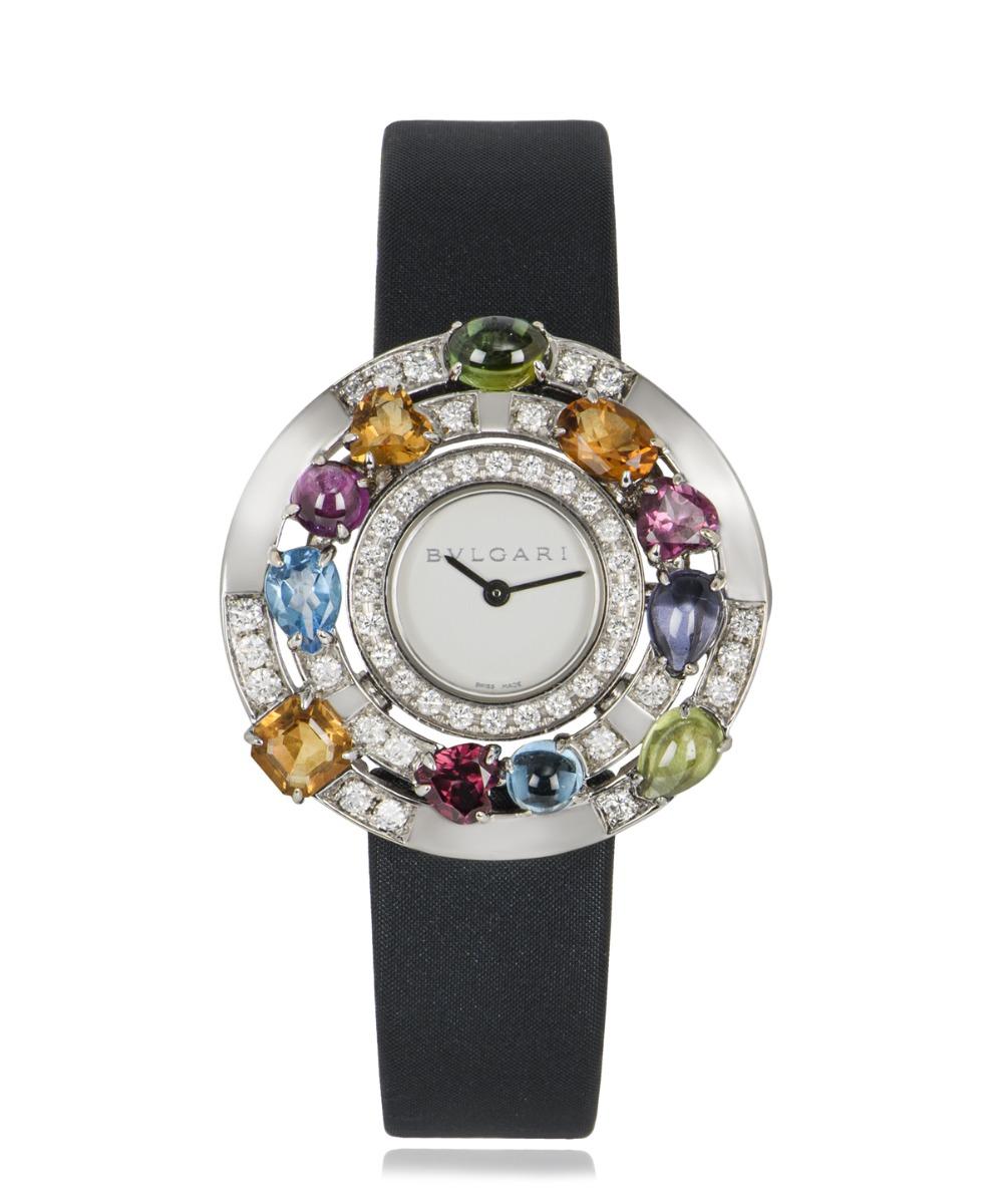 A stunning multi-gem ladies Astrale wristwatch, crafted in white gold by Bvlgari, featuring a white dial. Complimenting the dial is 44 round brilliant diamonds and is further set with multi gems that range from dark green tourmaline, iolite, blue