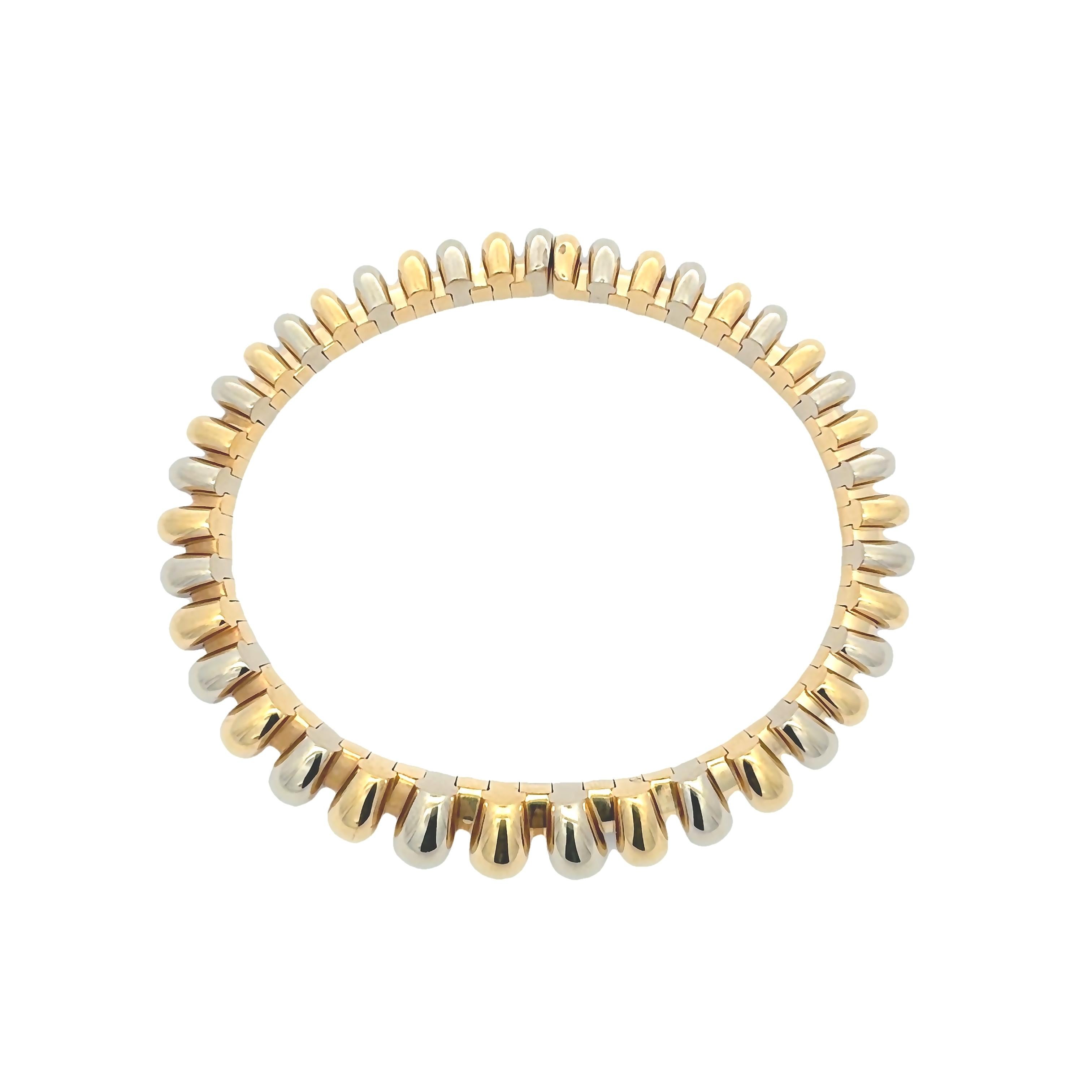 Un élégant bracelet bangle, présentant des disques en or blanc et jaune 18 carats en alternance. Parfait pour une tenue décontractée. Signé Bvlgari.