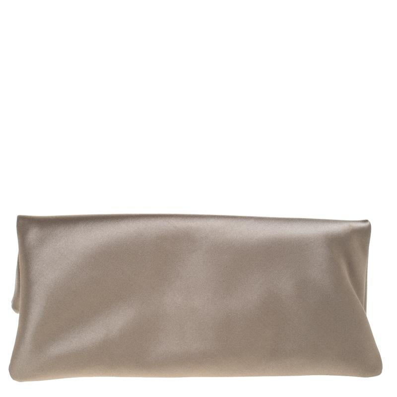 Handbags are more than just instruments to carry one's essentials. They speak of a woman's sense of style and the better the bag, the more confidence she gets when she holds it. This clutch is one such creation. This beige satin Monete clutch from