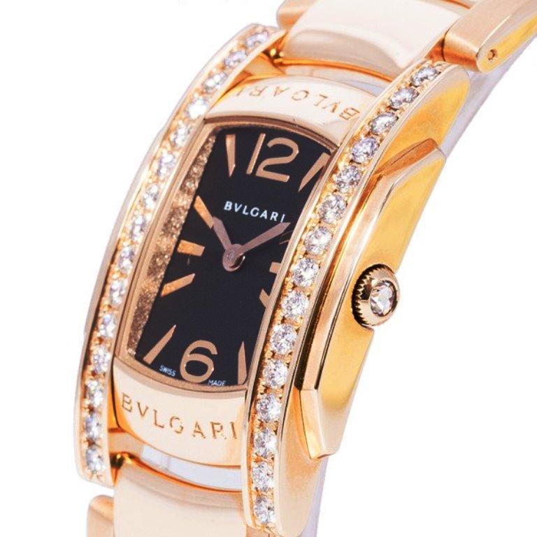 This Bvlagari wristwatch is designed for women from the Assioma collection. It features an 18 K rose-gold body. with the brand name engraved on the dial. It is highlighted by two strips of crystals on either side of the watch face. A chain strap