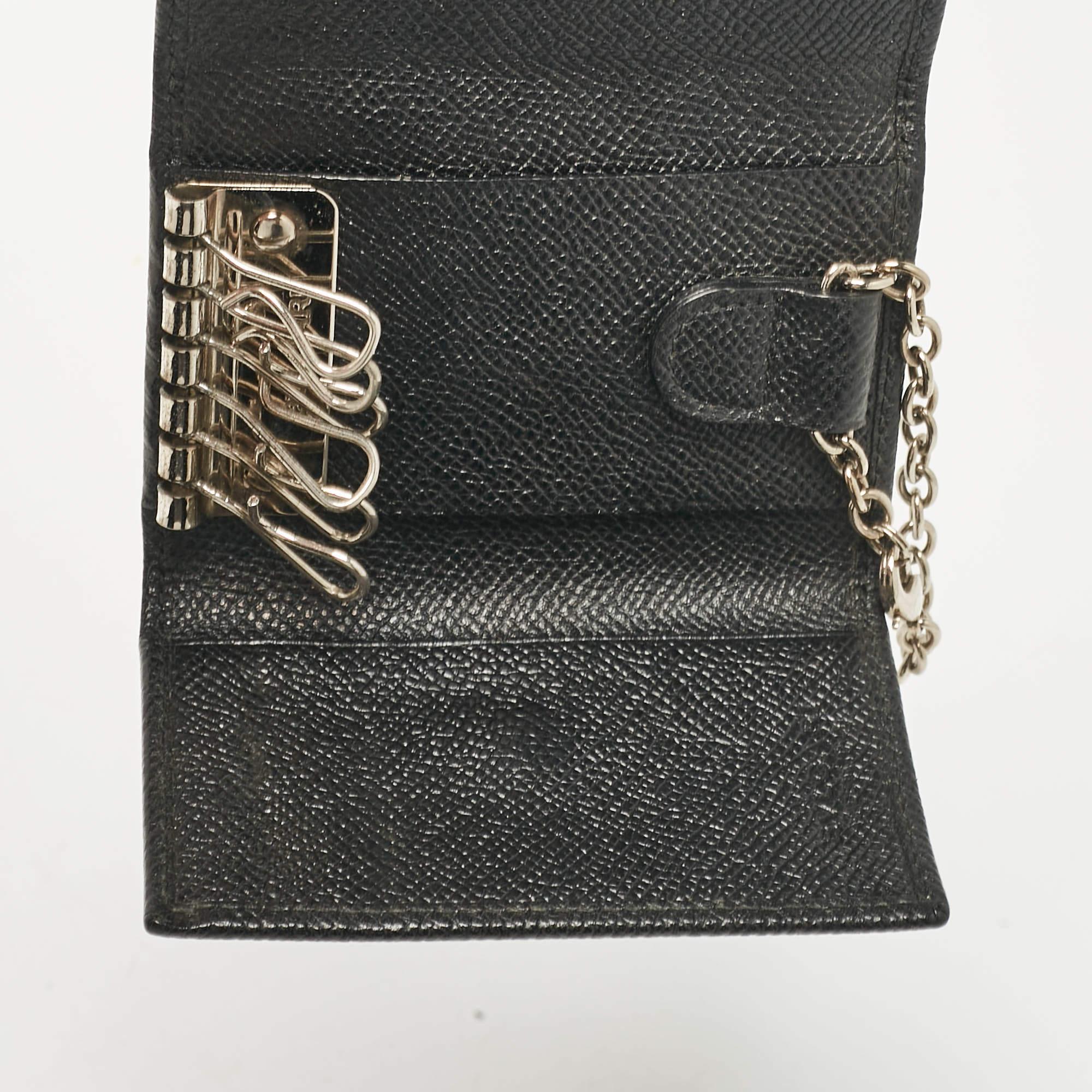 Crafted from sleek black leather this Bvlgari flap key holder exudes refined practicality. Featuring a compact design with multiple key rings it's perfect for keeping essentials secure. The signature logo detail on the front adds a touch of