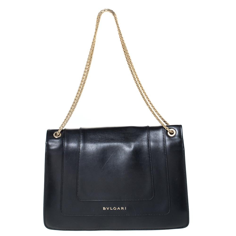 Dazzle the eyes that fall on you when you swing this stunning Bvlgari creation. Crafted from leather in a breathtaking black hue, the bag is styled with a flap that has the iconic Serpenti head closure. The bag has a spacious canvas interior and a