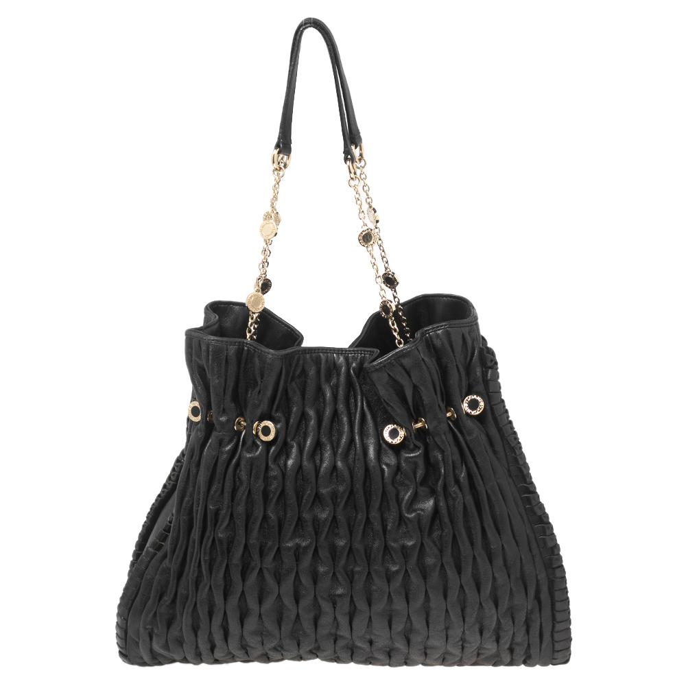 It is time you owned a statement Bvlgari handbag. Experience the touch of the finest craftsmanship and an aura of regality with this immaculately crafted leather tote. It featured a pleated exterior and a roomy interior. Elegantly black, this tote