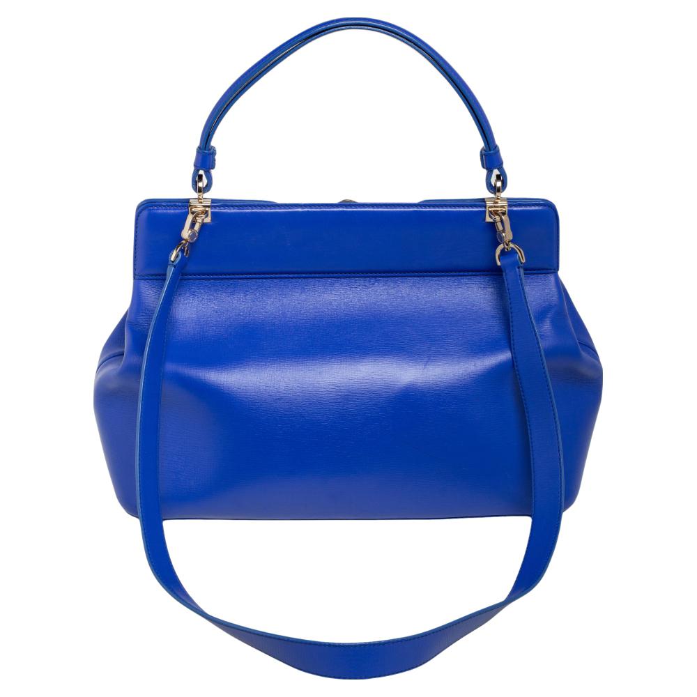 This Isabella Rossellini bag from Bvlgari is crafted from blue leather and has a refined design. The bag comes with protective metal feet, a top handle, and a shoulder strap. The turn-lock closure opens to a fabric-lined interior capacious enough to