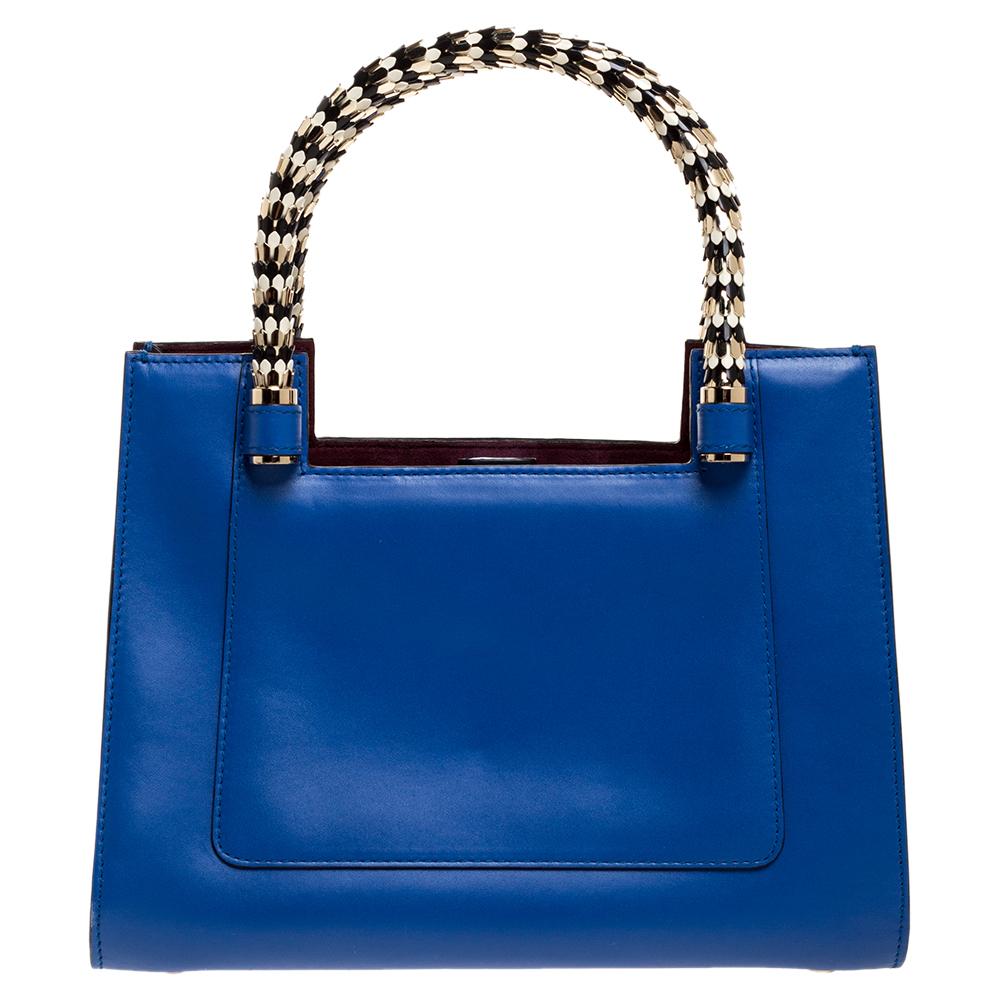 Bvlgari's Serpenti collection has stunning creations and this tote is a fine example. Crafted from blue leather, the Serpenti Scaglie tote is styled with retractable snake handles and maroon leather panels on the sides. The bag comes with a spacious