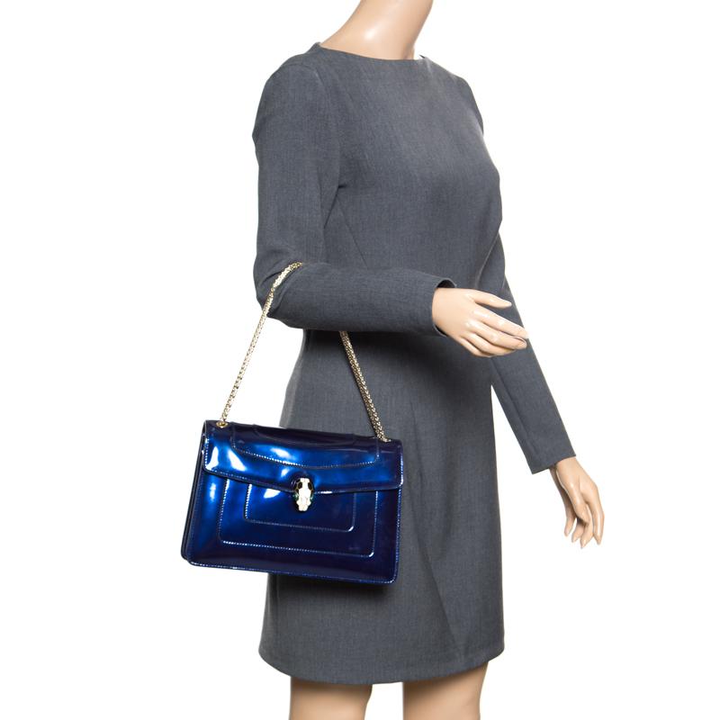 This stunning Bvlgari creation is crafted from patent leather in a breathtaking blue hue. The shoulder bag is styled with a flap that has the iconic Serpenti head closure. The bag comes with a well-sized fabric lined interior that houses a zip