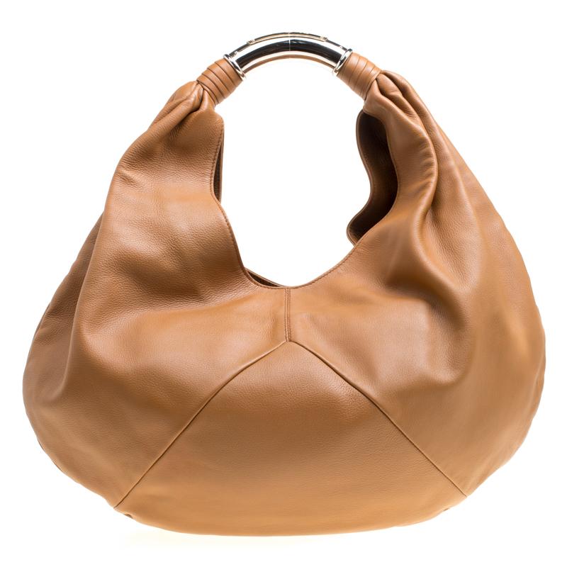 Crafted from leather, this brown hobo from Bvlgari is designed with minimal style details but with high attention to craftsmanship so that it may assist you with durability. The spacious interior of the bag is lined with leather and the hobo is held