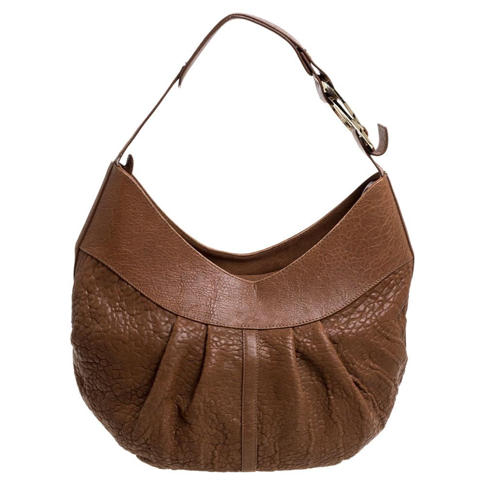 This hobo from Bvlgari is a fabulous piece. The bag has been crafted from pebbled leather in a pleated style flaunting a gorgeous brown shade and equipped with a single handle and gold-tone hardware. The spacious interior comes with a zipped