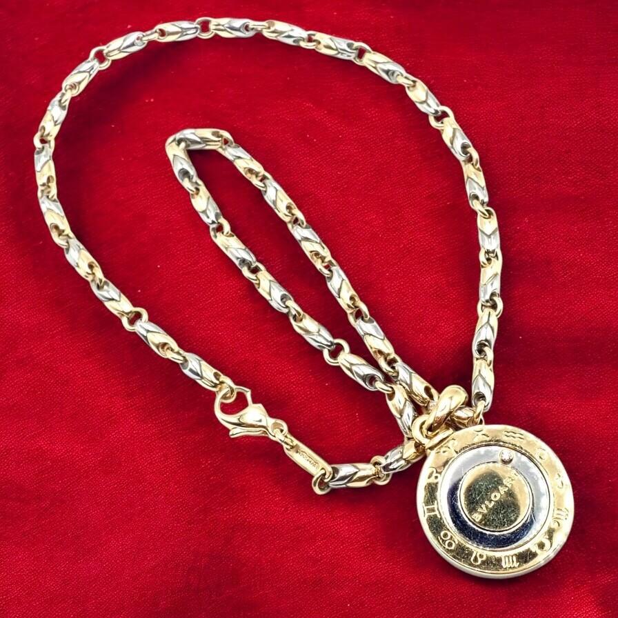 18k yellow gold and stainless steel vintage diamond Horoscope Zodiac pendant necklace by Bulgari.
The Bulgari Bvlgari Zodiac Pendant Necklace combines 18k yellow gold, stainless steel, and a brilliant diamond. 
Featuring engraved zodiac signs in a