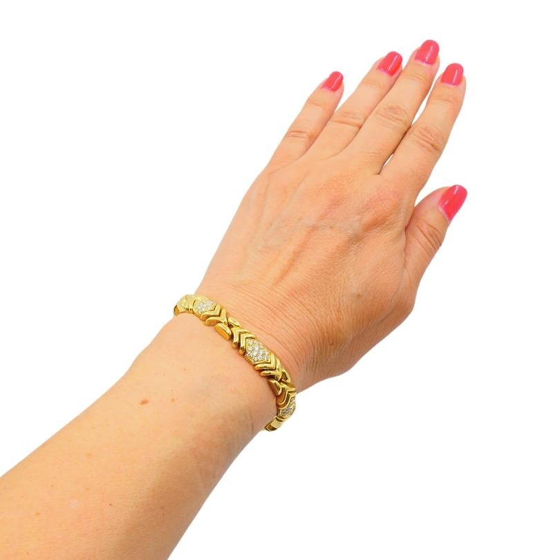 A Bulgari bracelet crafted in 18k yellow gold, featuring diamonds.
This diamond gold bracelet features a sought-after geometric pattern that alternates between solid gold links and pavé-set diamond segments. The repeating chevron motif gives it a