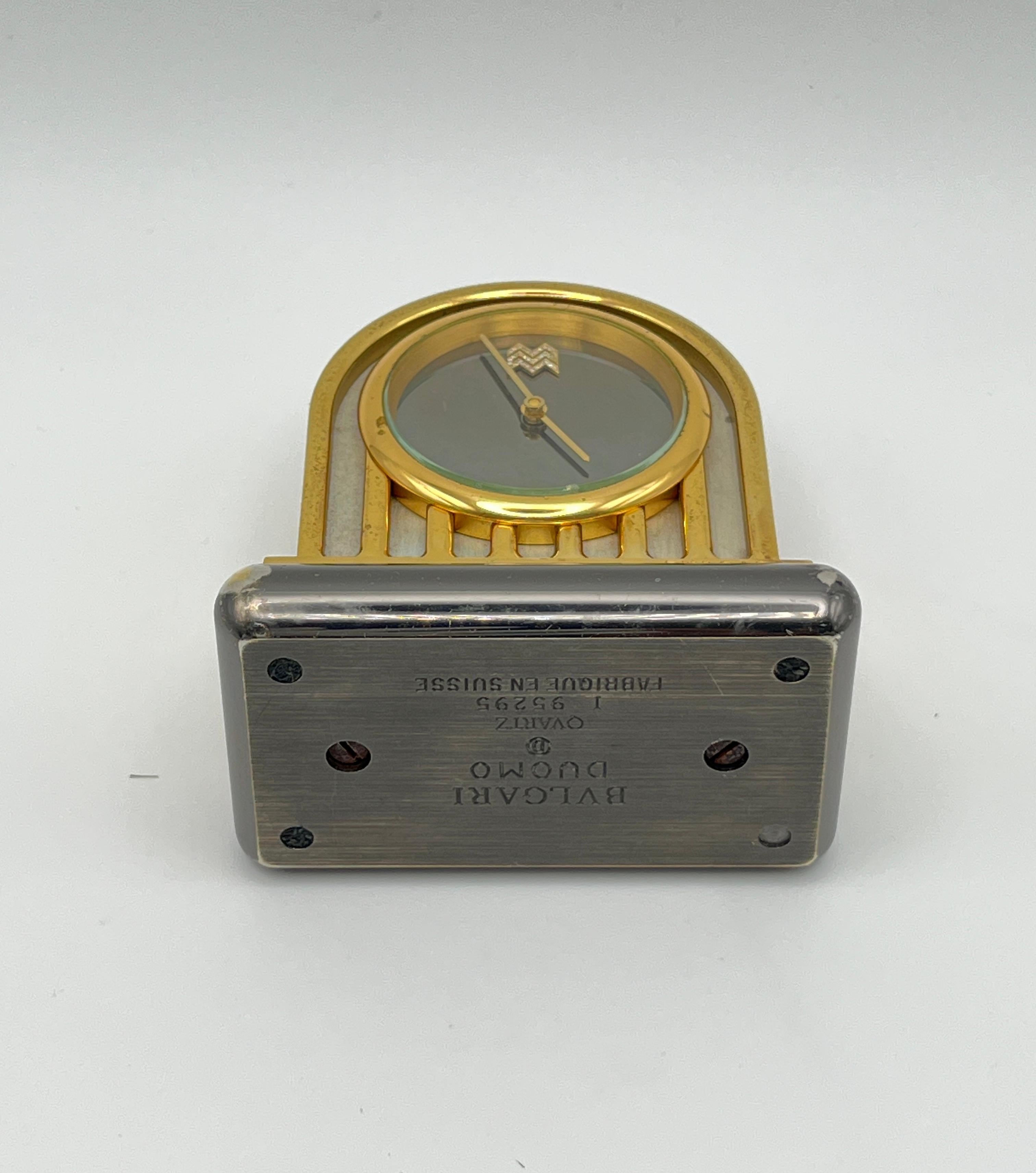 A rare and substantial desk accessory crafted by Bvlgari, circa late 1980s–1990s. This striking “Duomo” design is sculpted in gilt brass with a polished steel base, conjuring the elegance of Italian architecture. The minimalist silver-tone dial