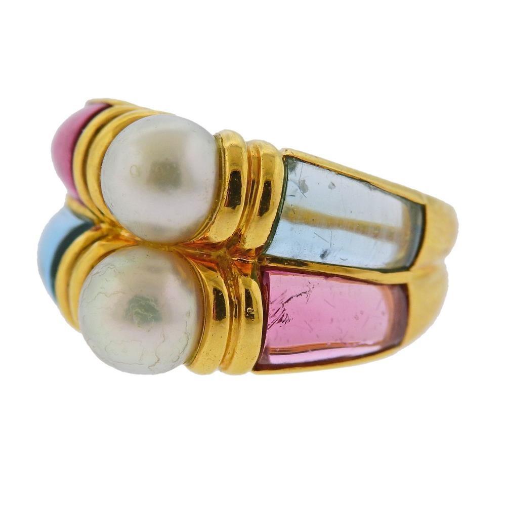 18k yellow gold ring by Bvlgari set with two pearls - 6.7mm , and side gemstones pink tourmaline and blue topaz. Ring size - 5.5, ring top is 15mm wide. Marked; Bvlgari, 750, Italian mark. Weight 14 grams.
