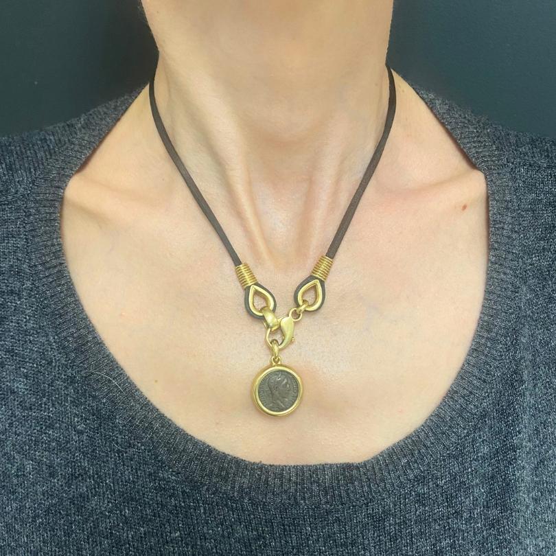 DESIGNER: Bvlgari
CIRCA: 1970s
MATERIALS: 18k Gold, Leather Cord
WEIGHT: 29.4 Grams
MEASUREMENTS:  Diameter - 13/16” , Length - 16